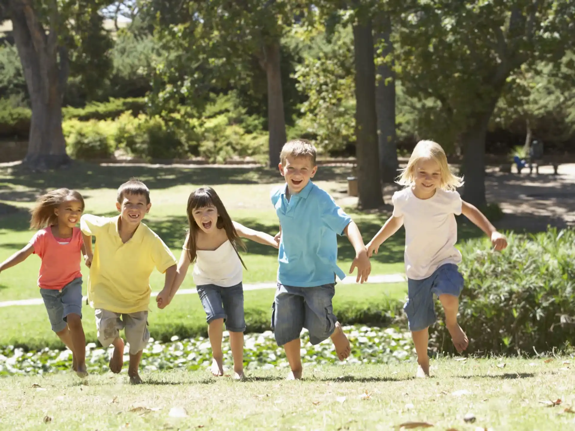 a group of children running in a park