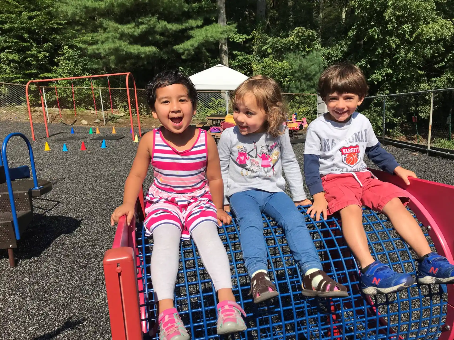 a group of children sitting on a playground swing