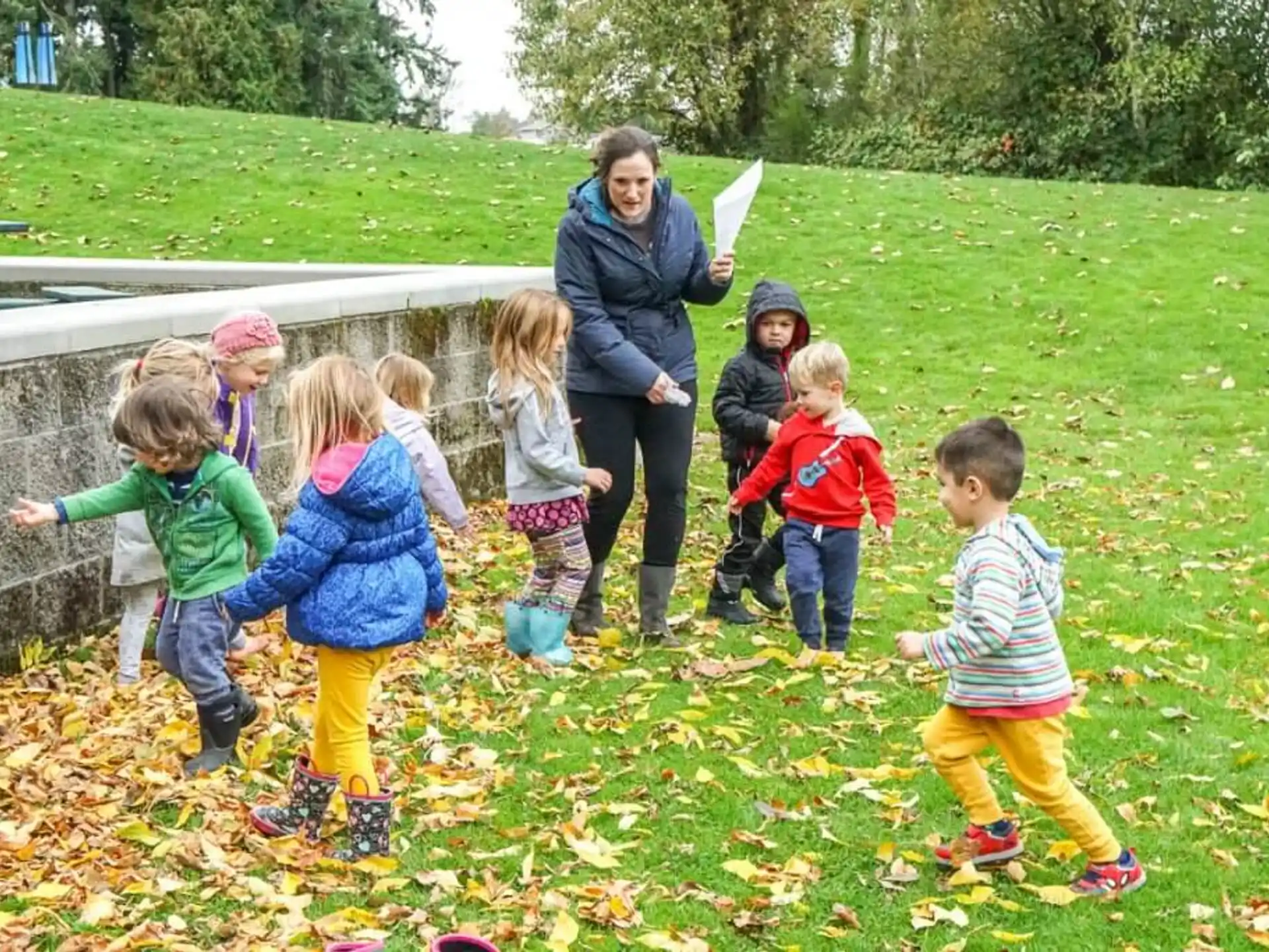 a group of children playing in a grassy area