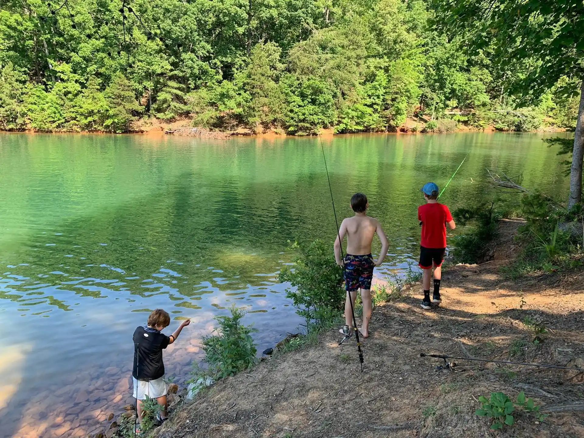 a group of people standing on a rock by a body of water