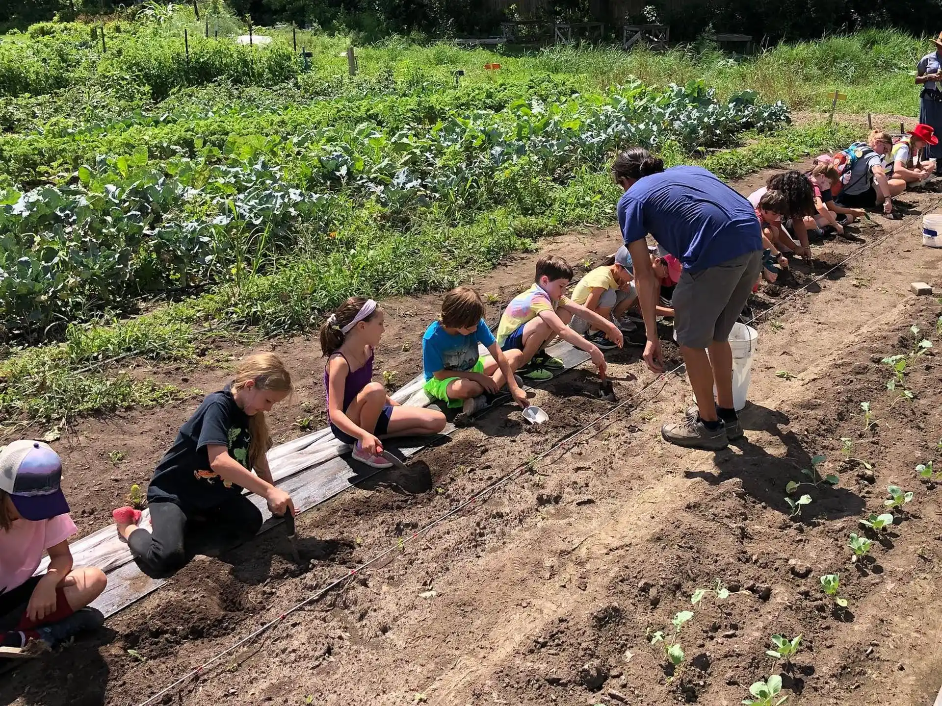 a group of people sitting on a bench in a field