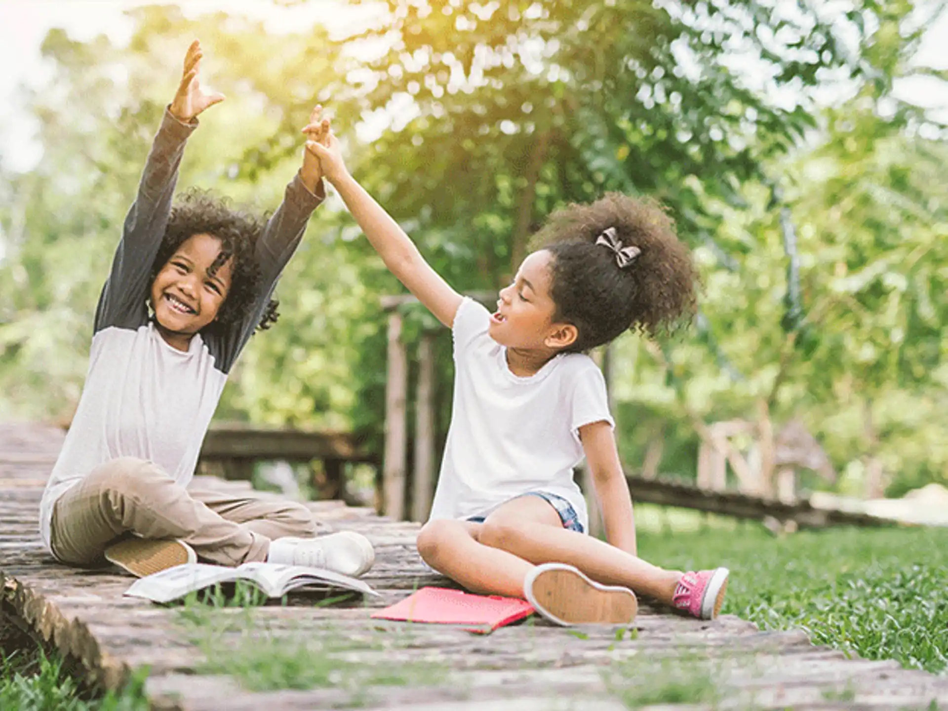 a person and a child sitting on a stone path with their arms up