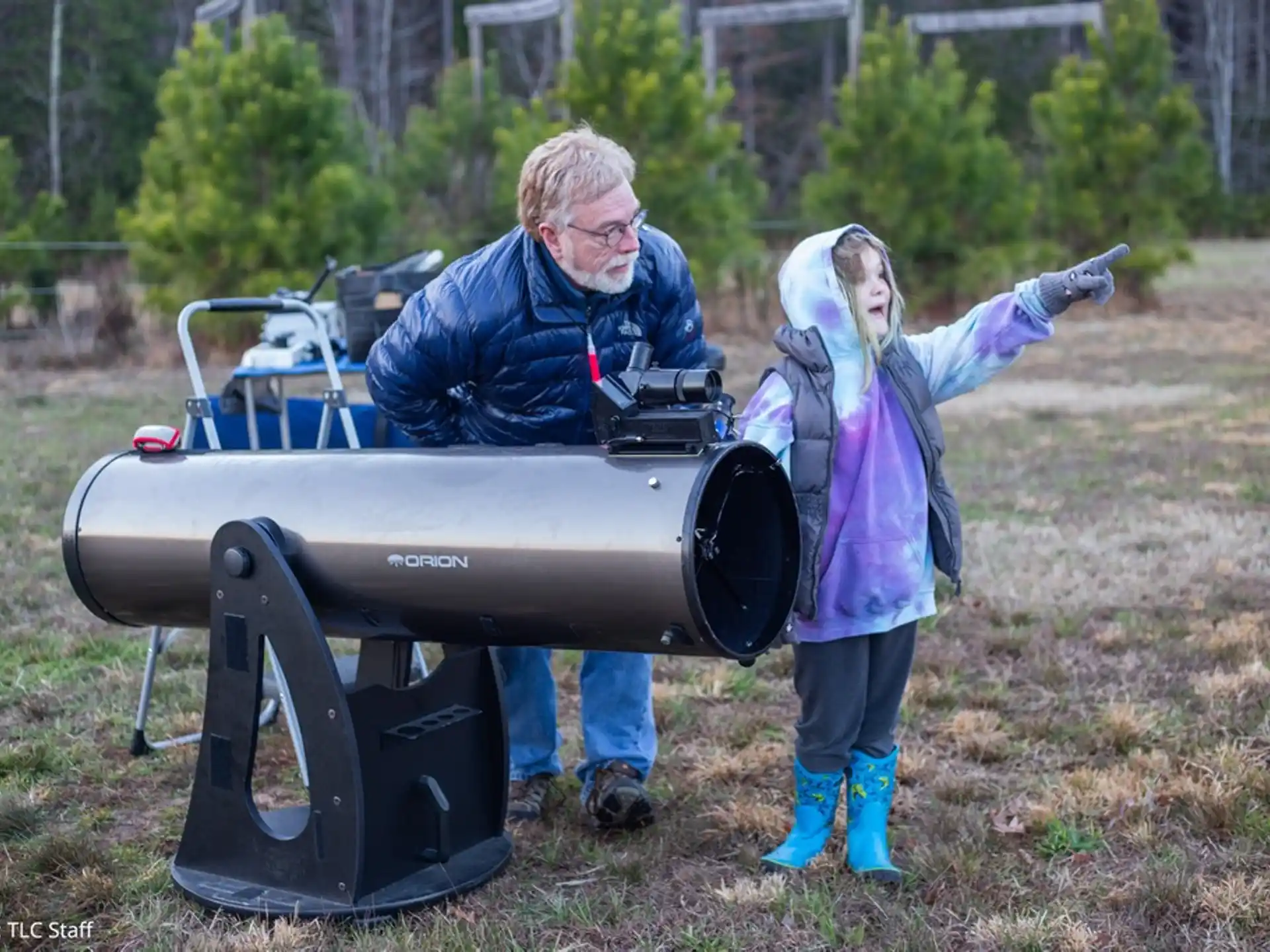 a man and a girl standing next to a lawn mower