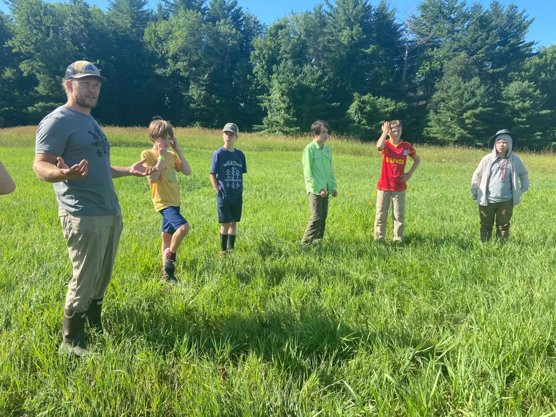 a group of people standing in a grassy field