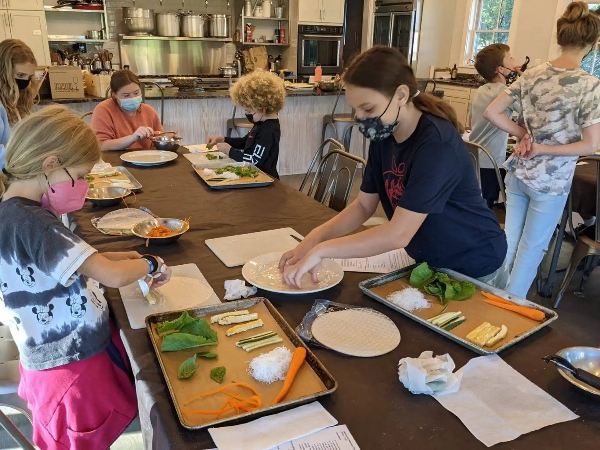 a group of people gather around a table full of food