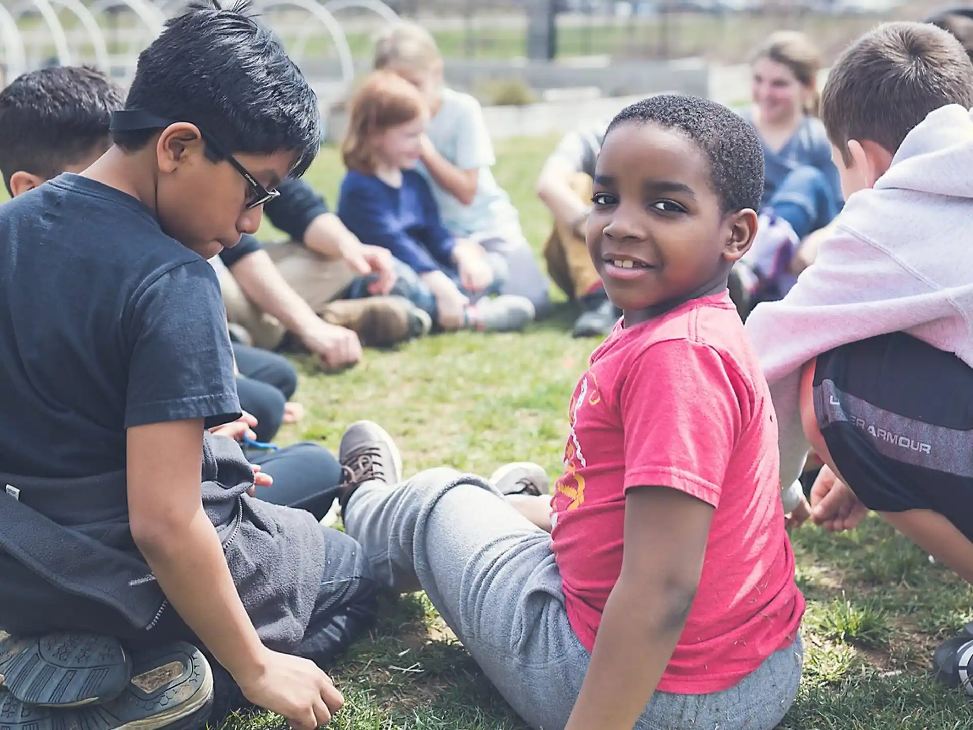 a group of people sitting on the grass