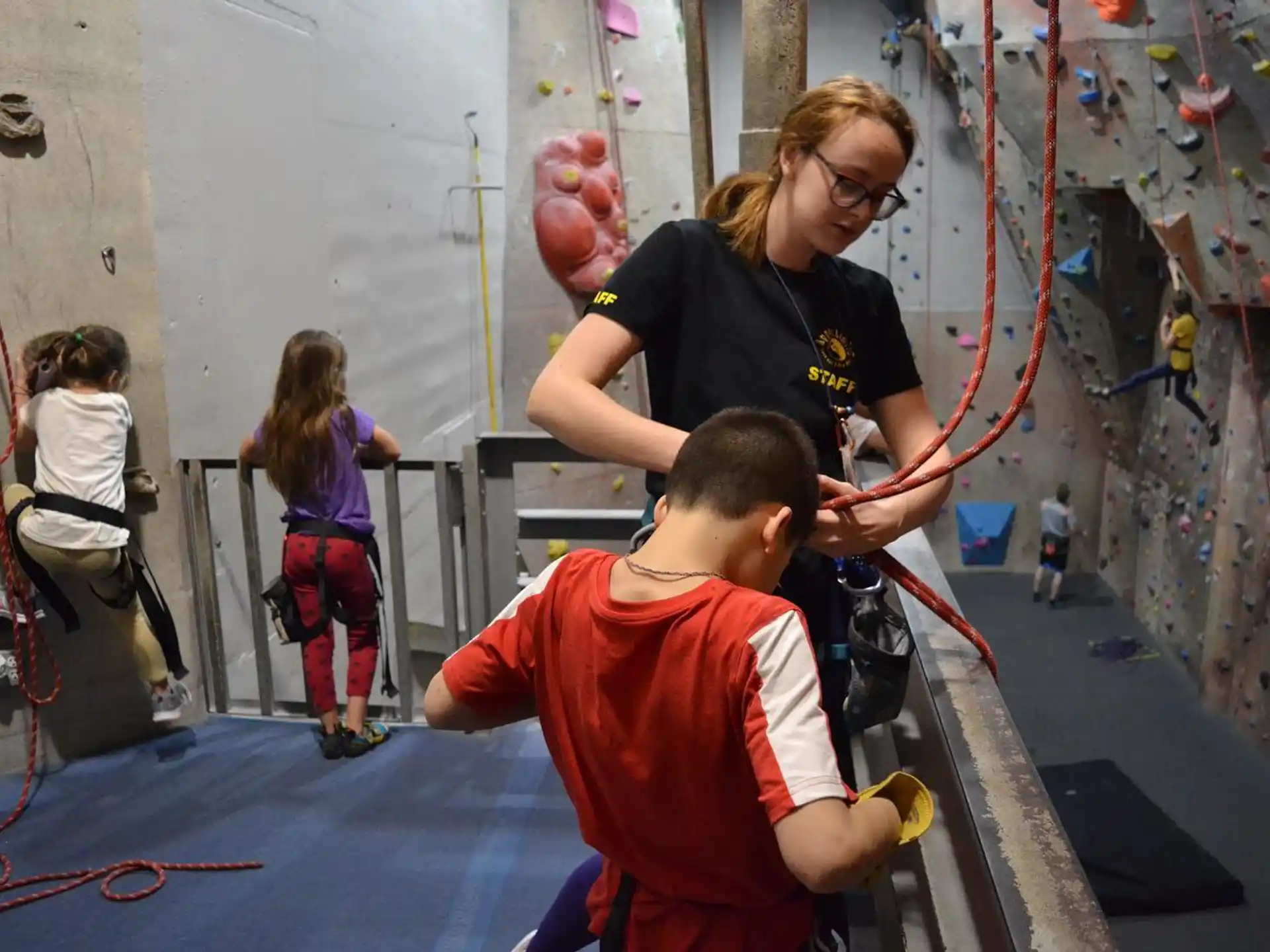 a person and a boy playing with a ball in a gym