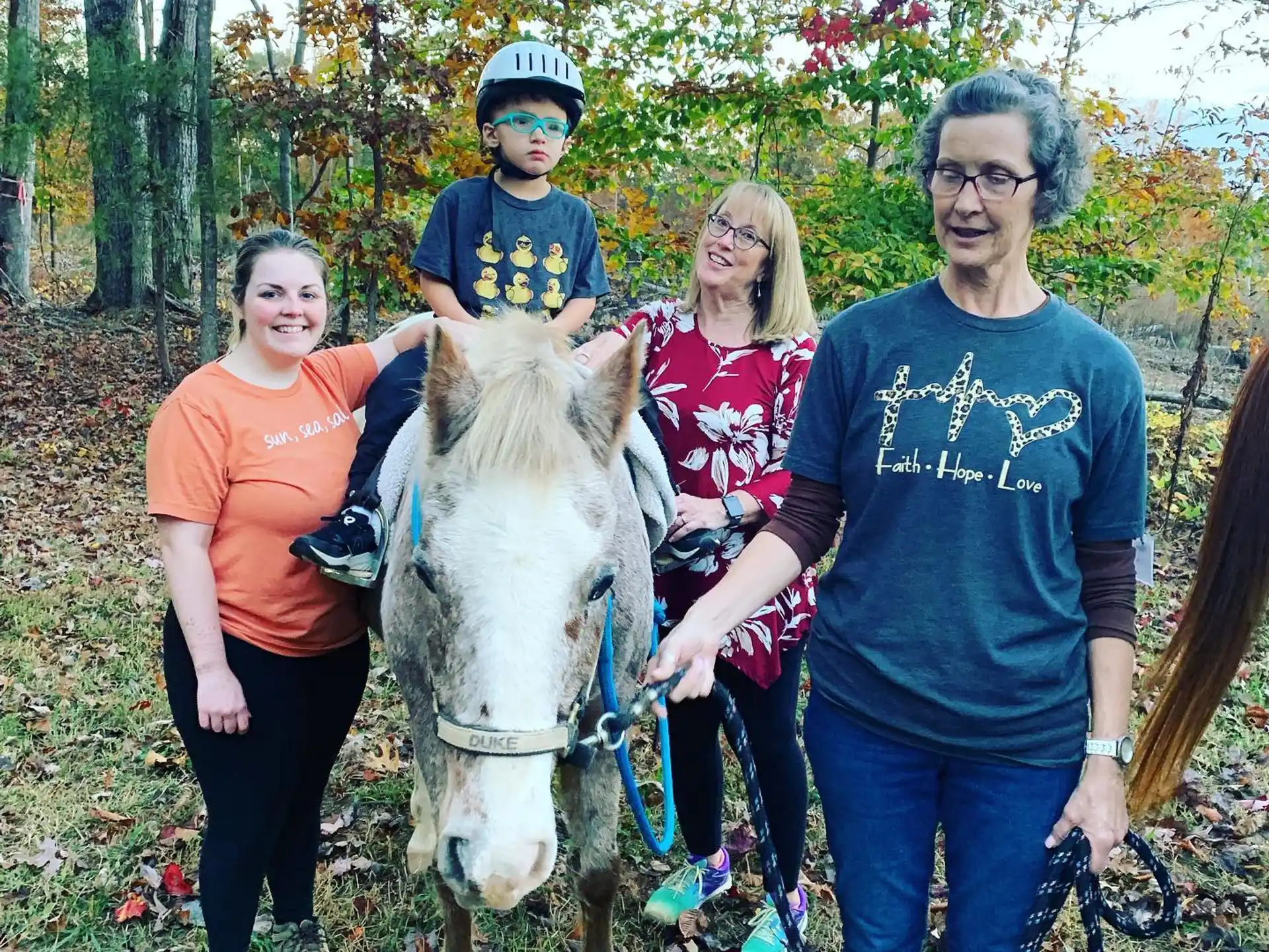 a group of people posing with a horse