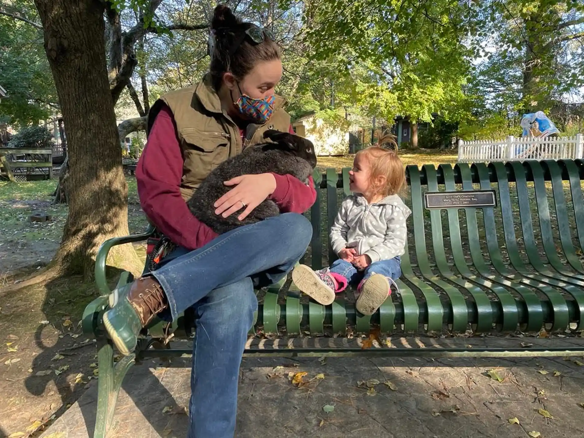 a person and a child sitting on a bench