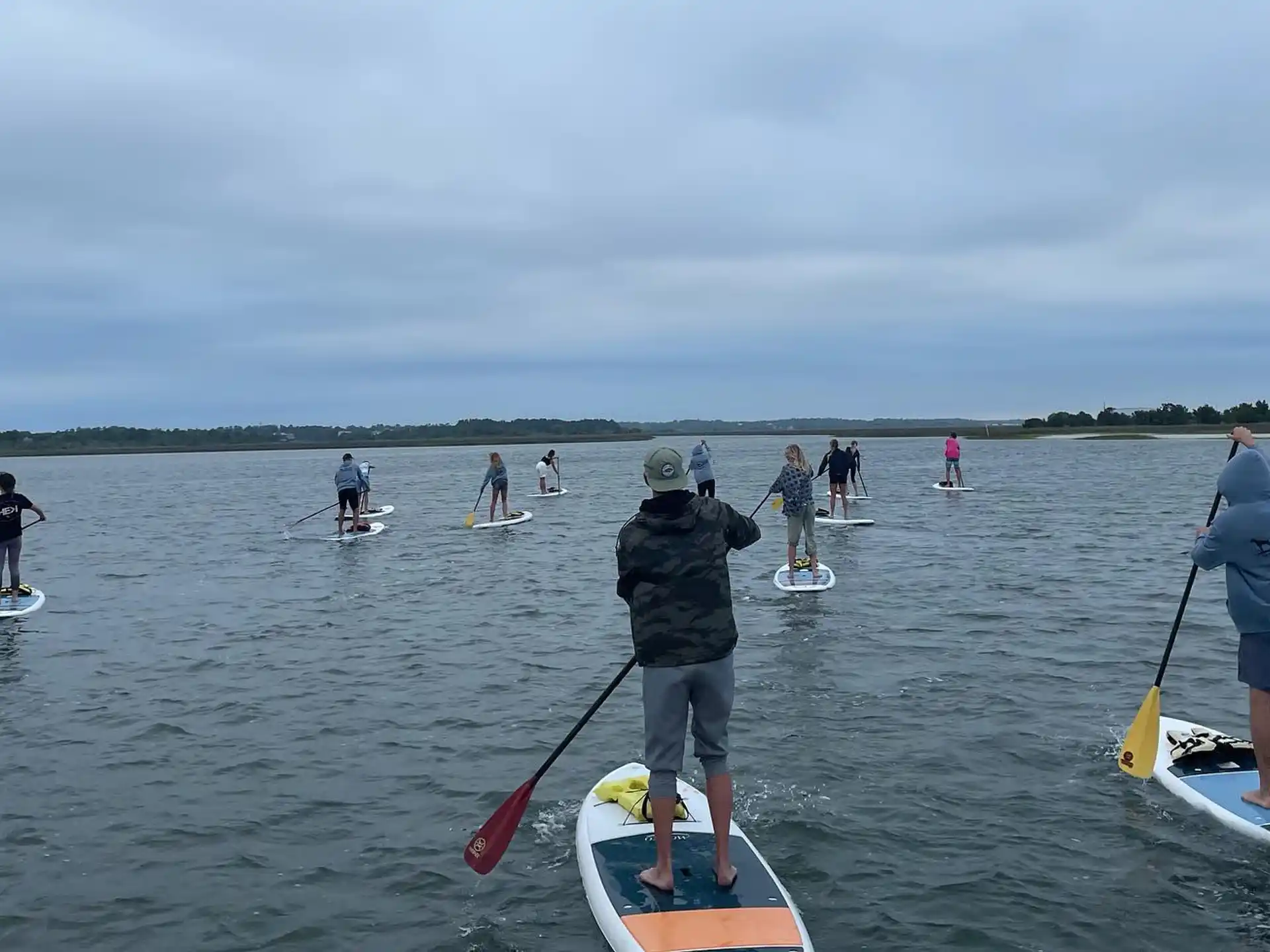 a group of people paddle on surfboards