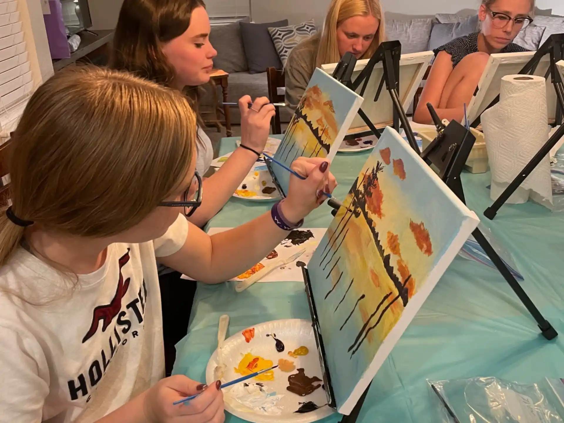 a group of people sitting at a table with art on it