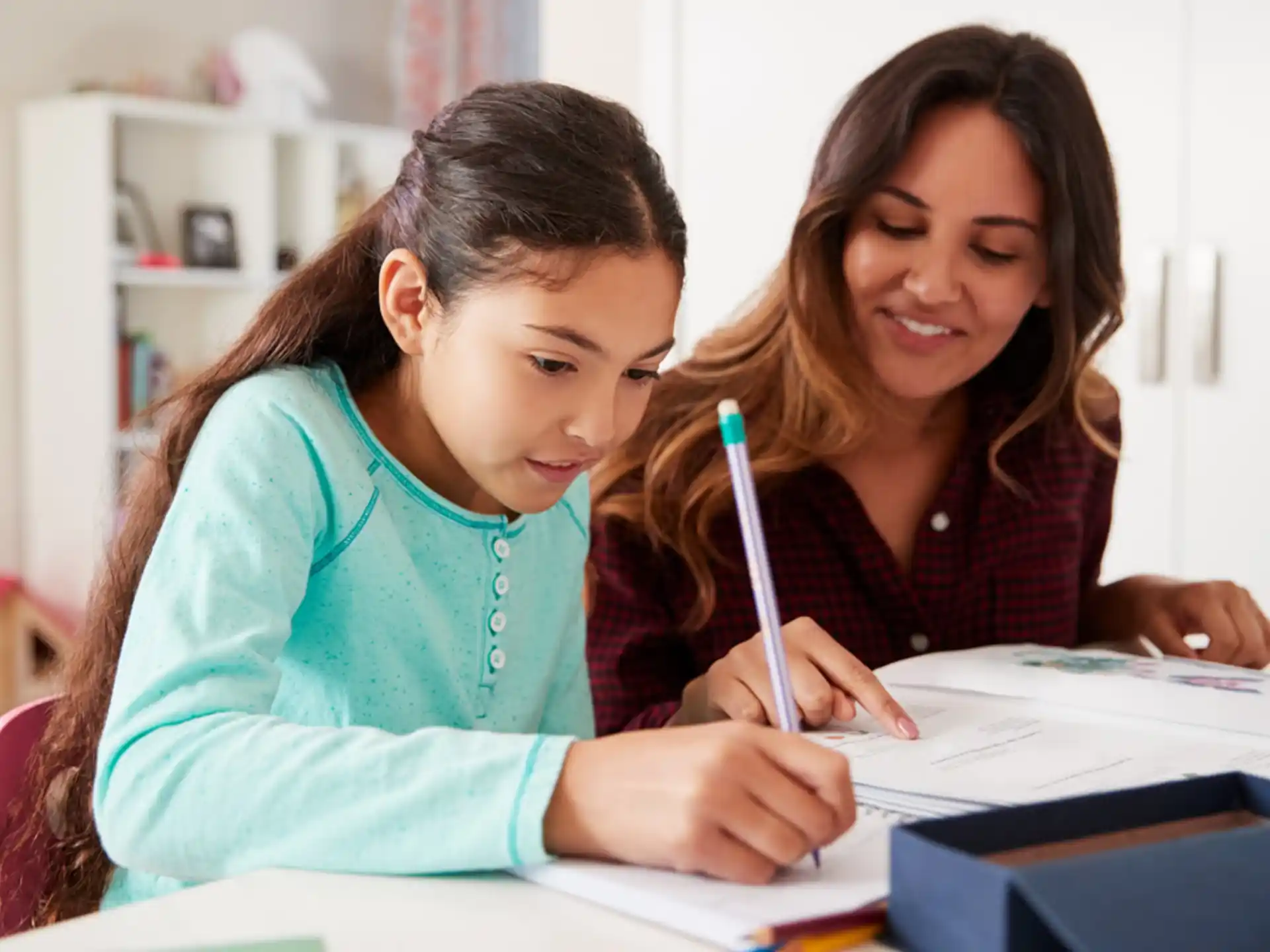 a woman and a child writing on a piece of paper