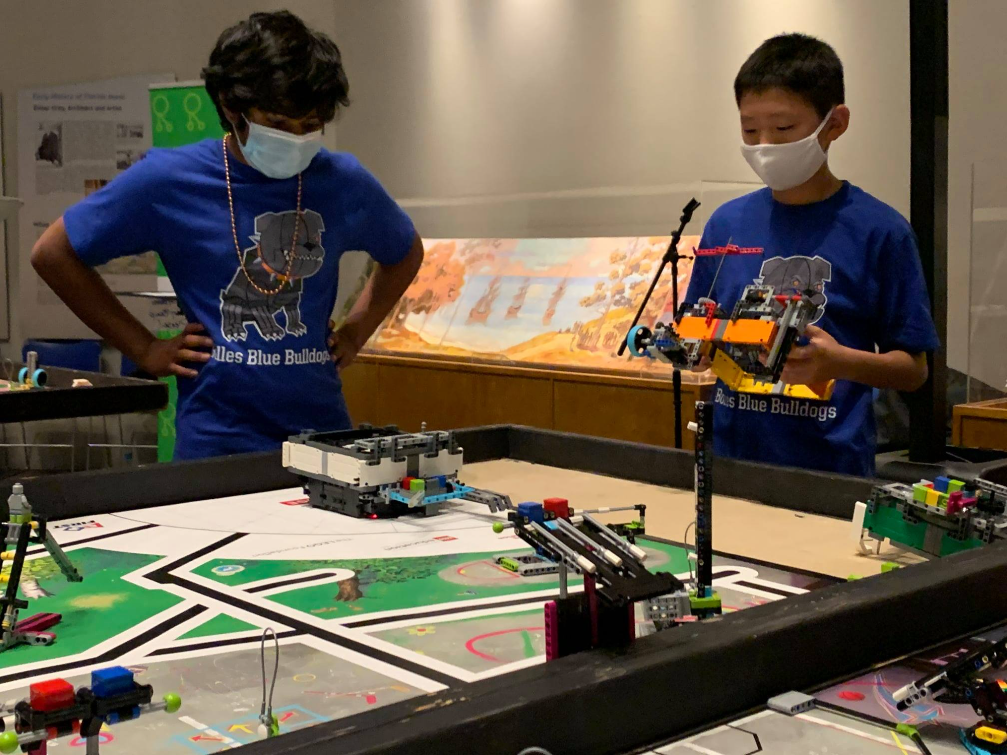 a couple of boys wearing masks and working on a project