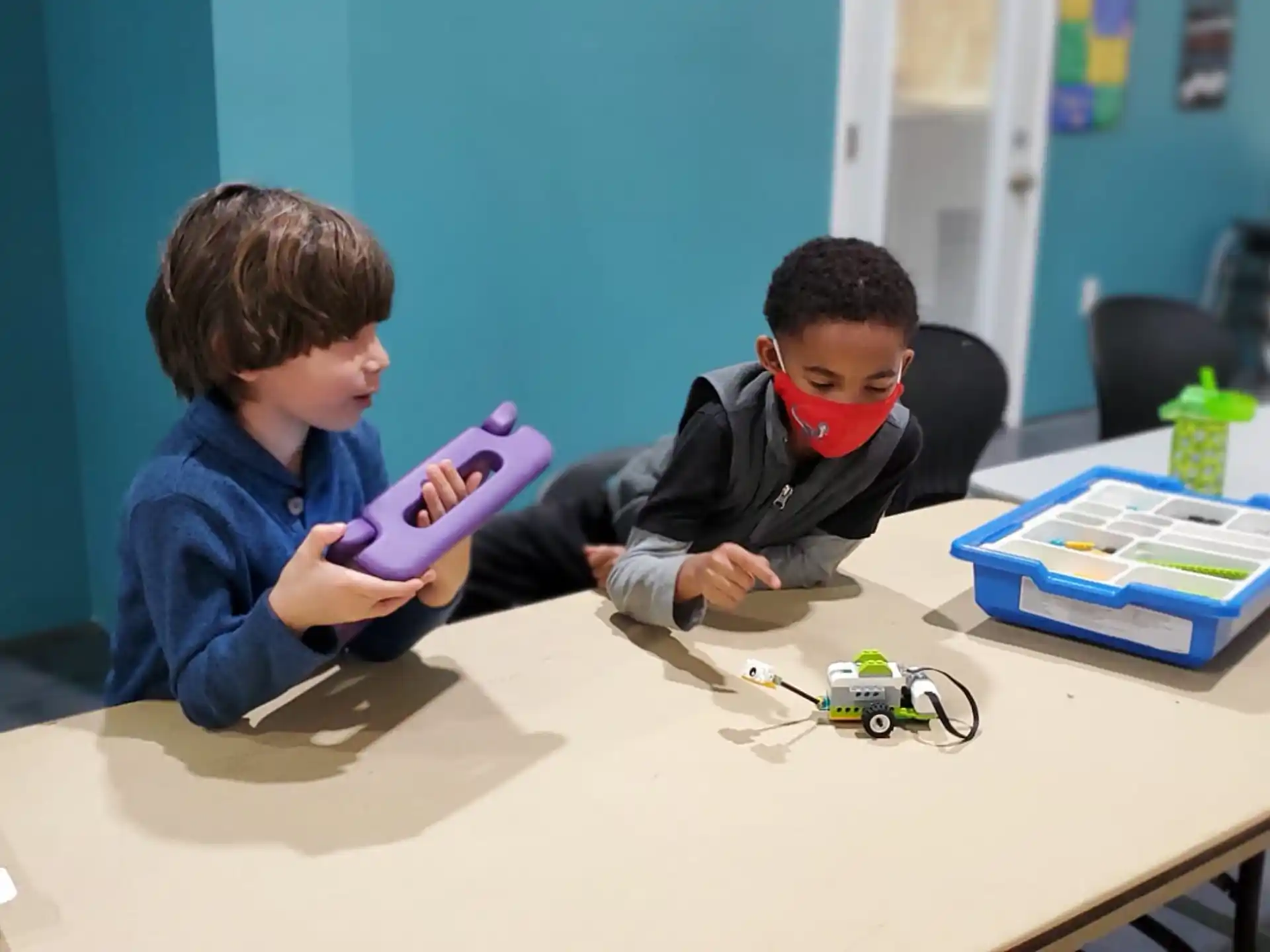 a couple of boys playing with a purple toy gun