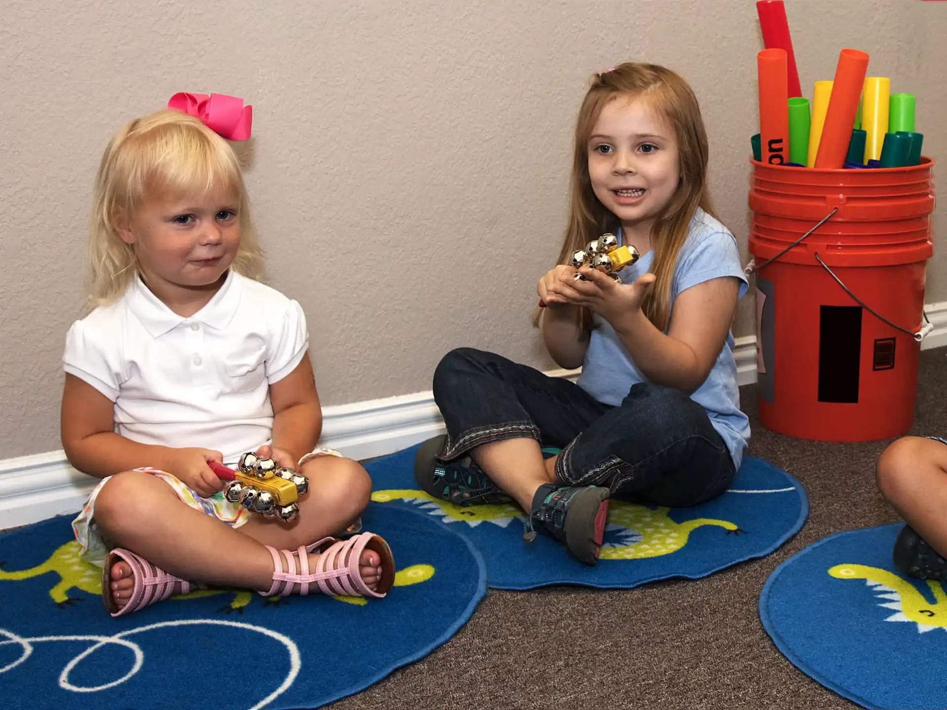 a couple of girls sitting on the floor eating food