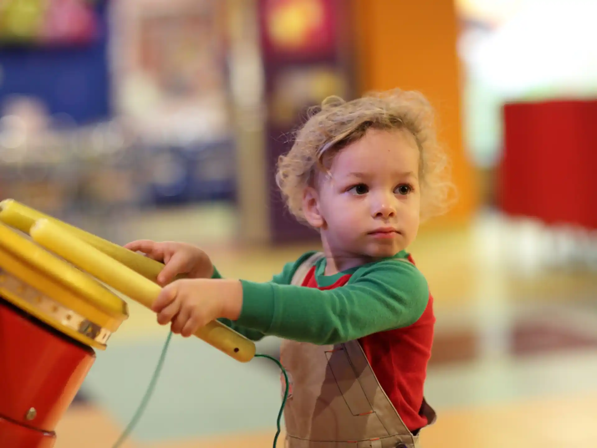 a young boy holding a yellow toy