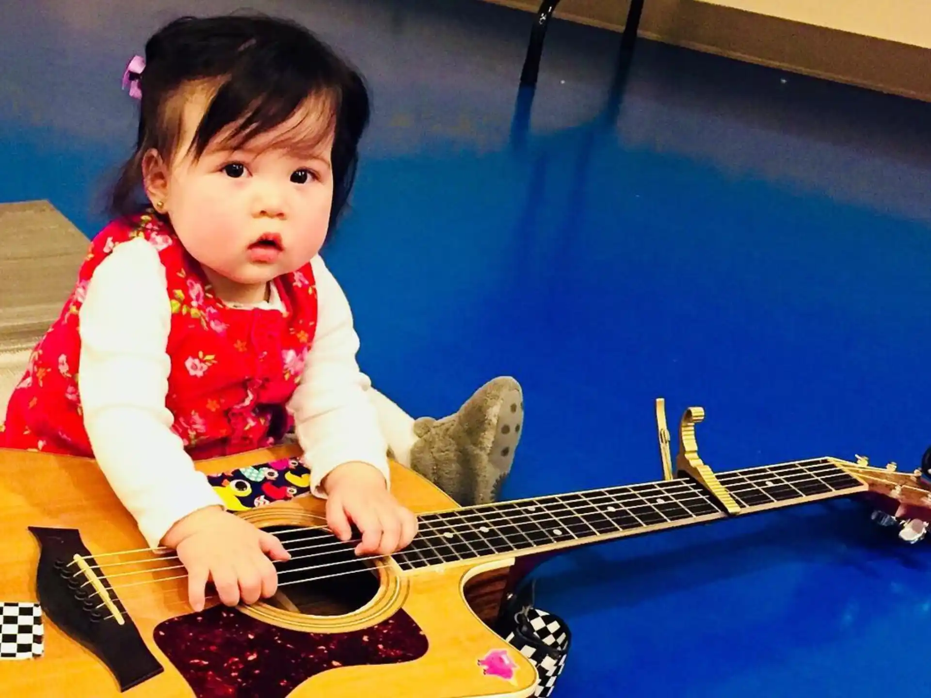 a baby playing a guitar