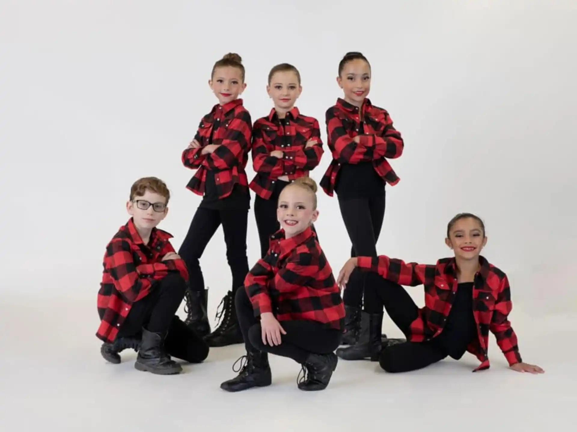 a group of boys in red and black plaid shirts