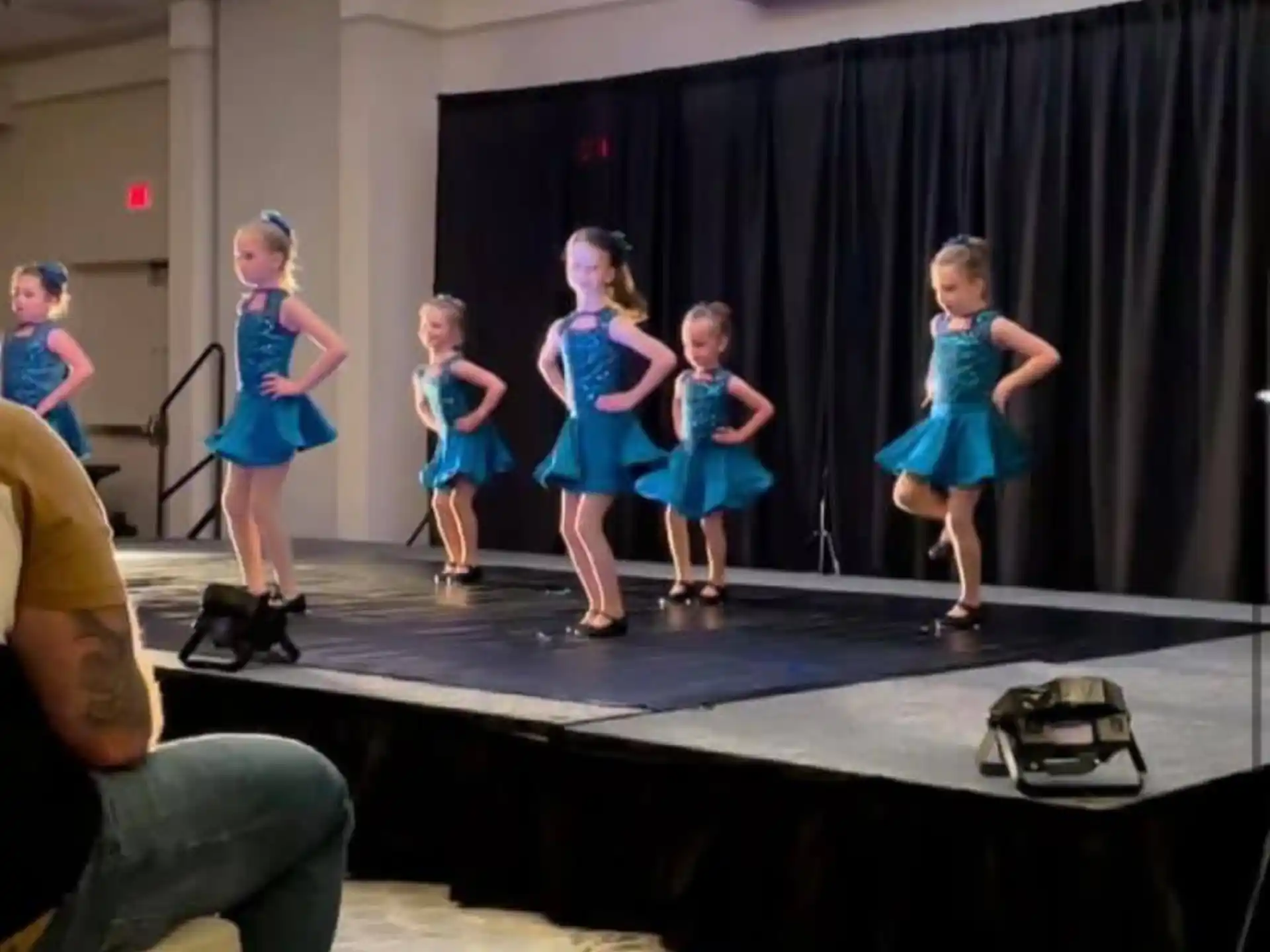 a group of girls in blue dresses on a stage