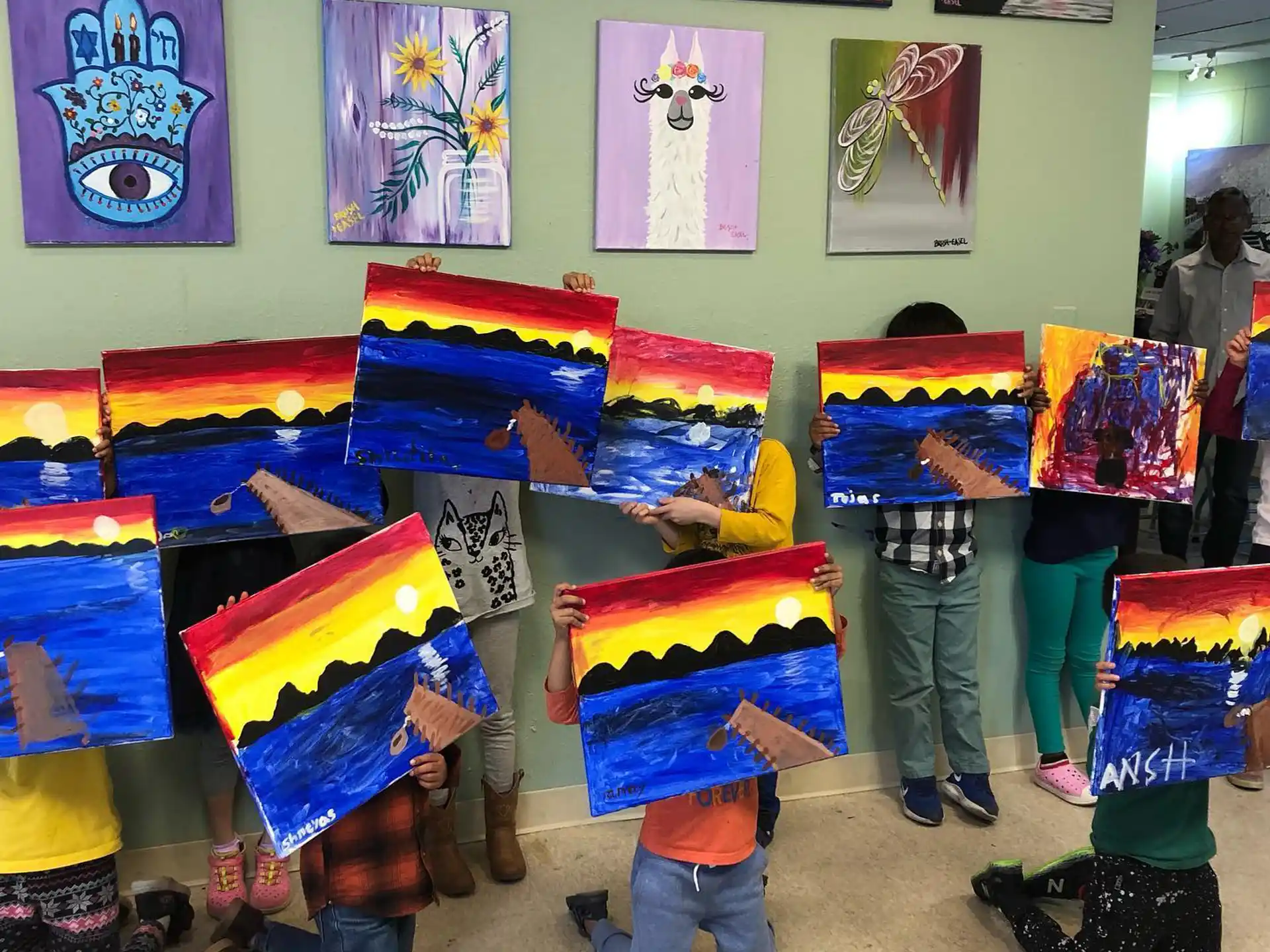 a group of kids in a room with art on the walls