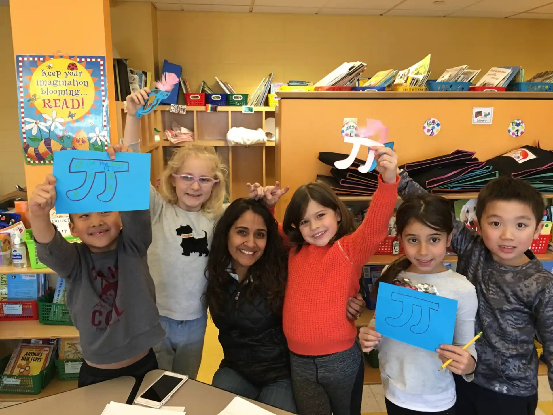 a group of children holding up blue and yellow signs in a classroom