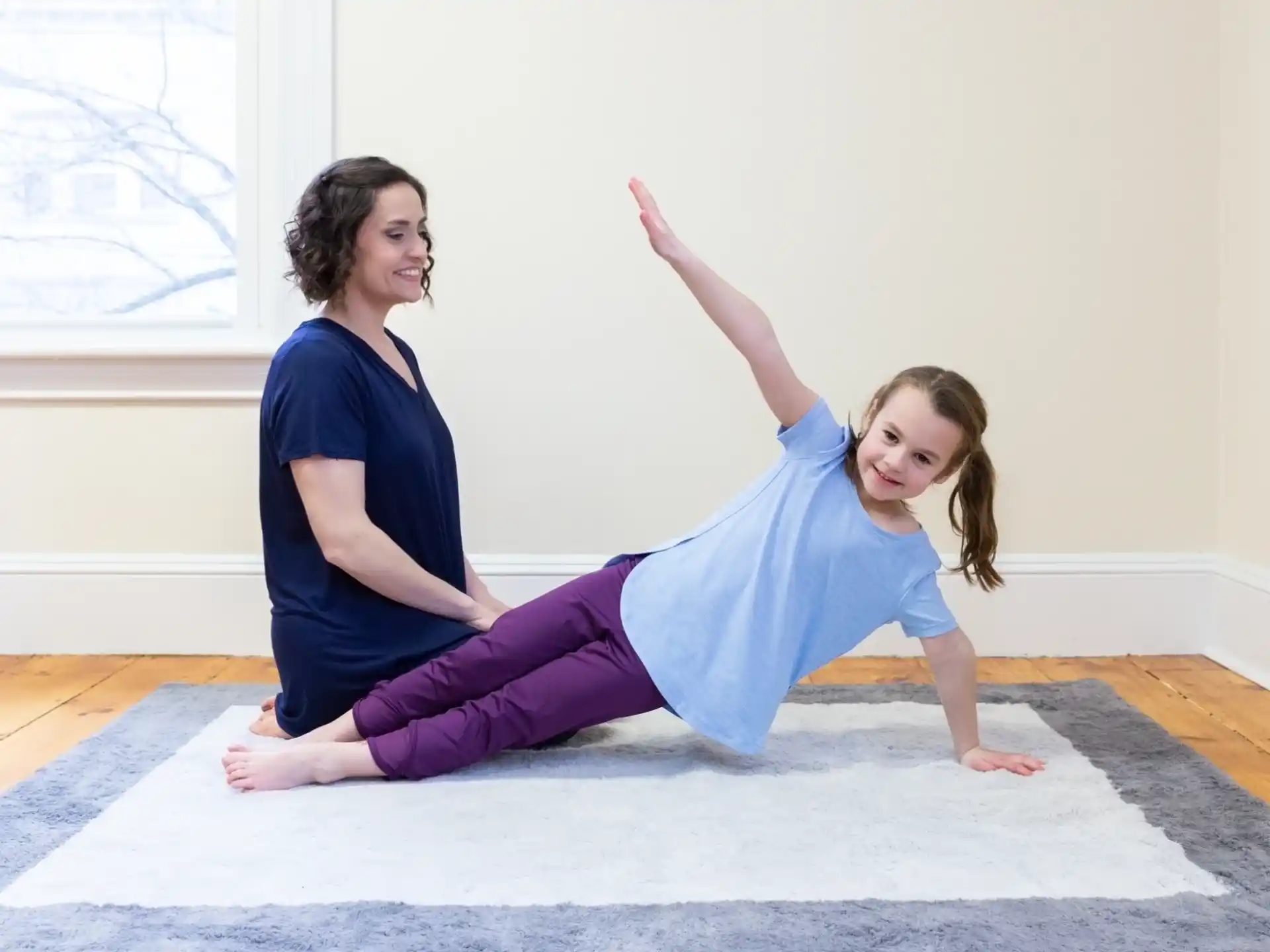 a person and a girl doing yoga