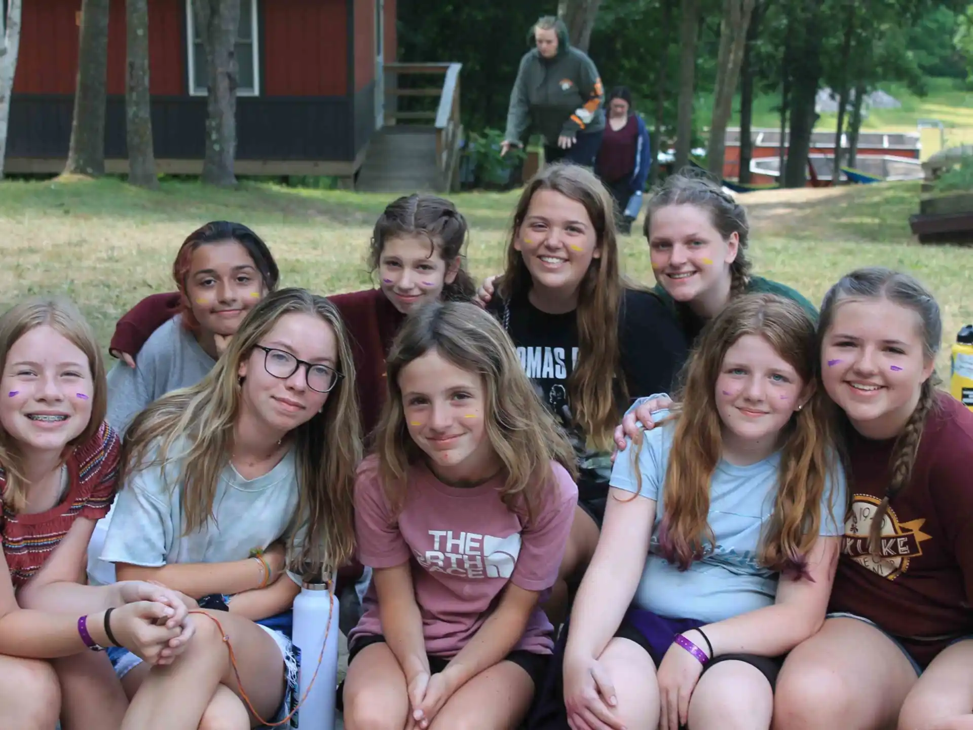 a group of girls sitting on a bench in a park