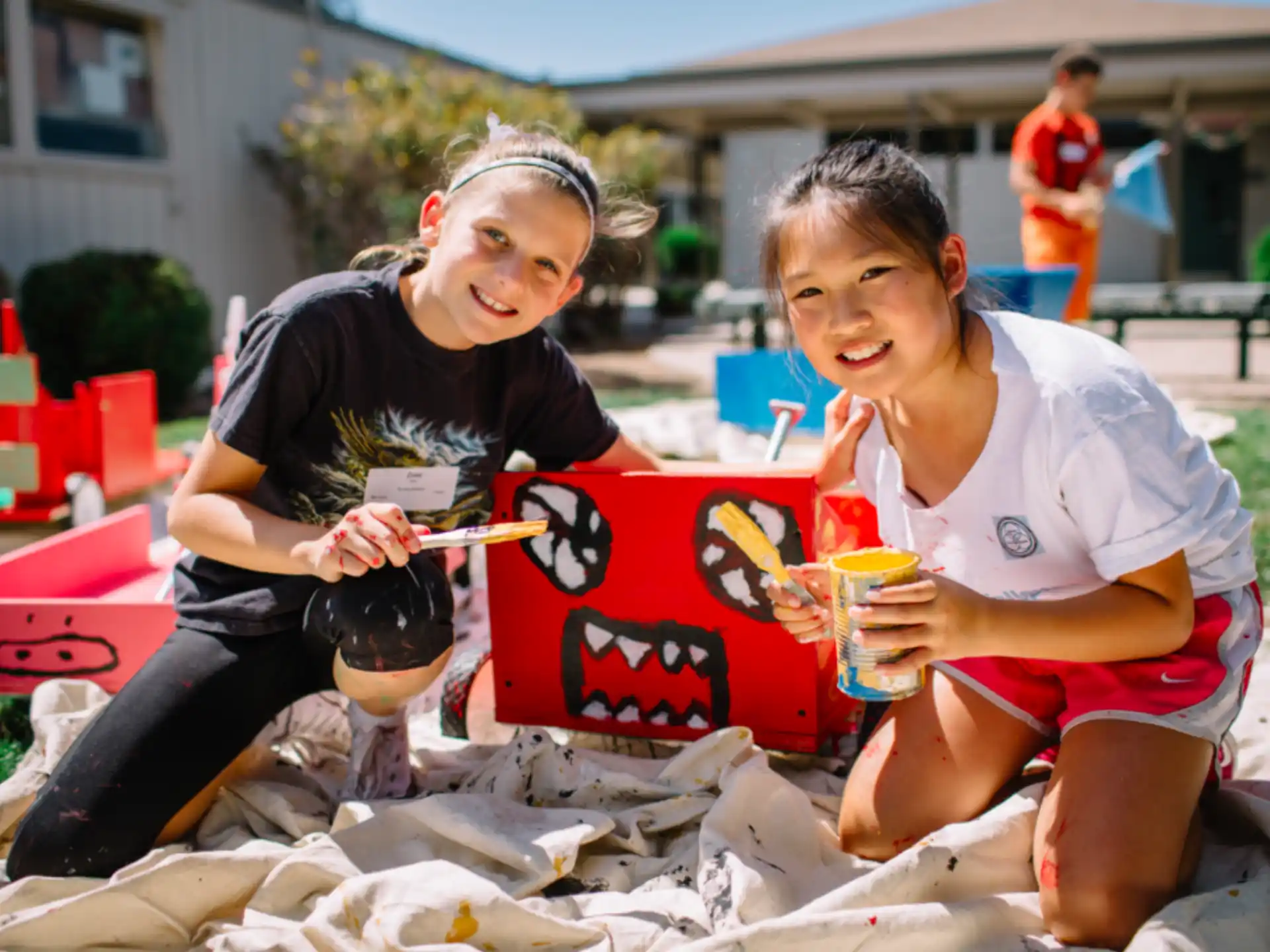 a couple of girls sitting on a pile of garbage
