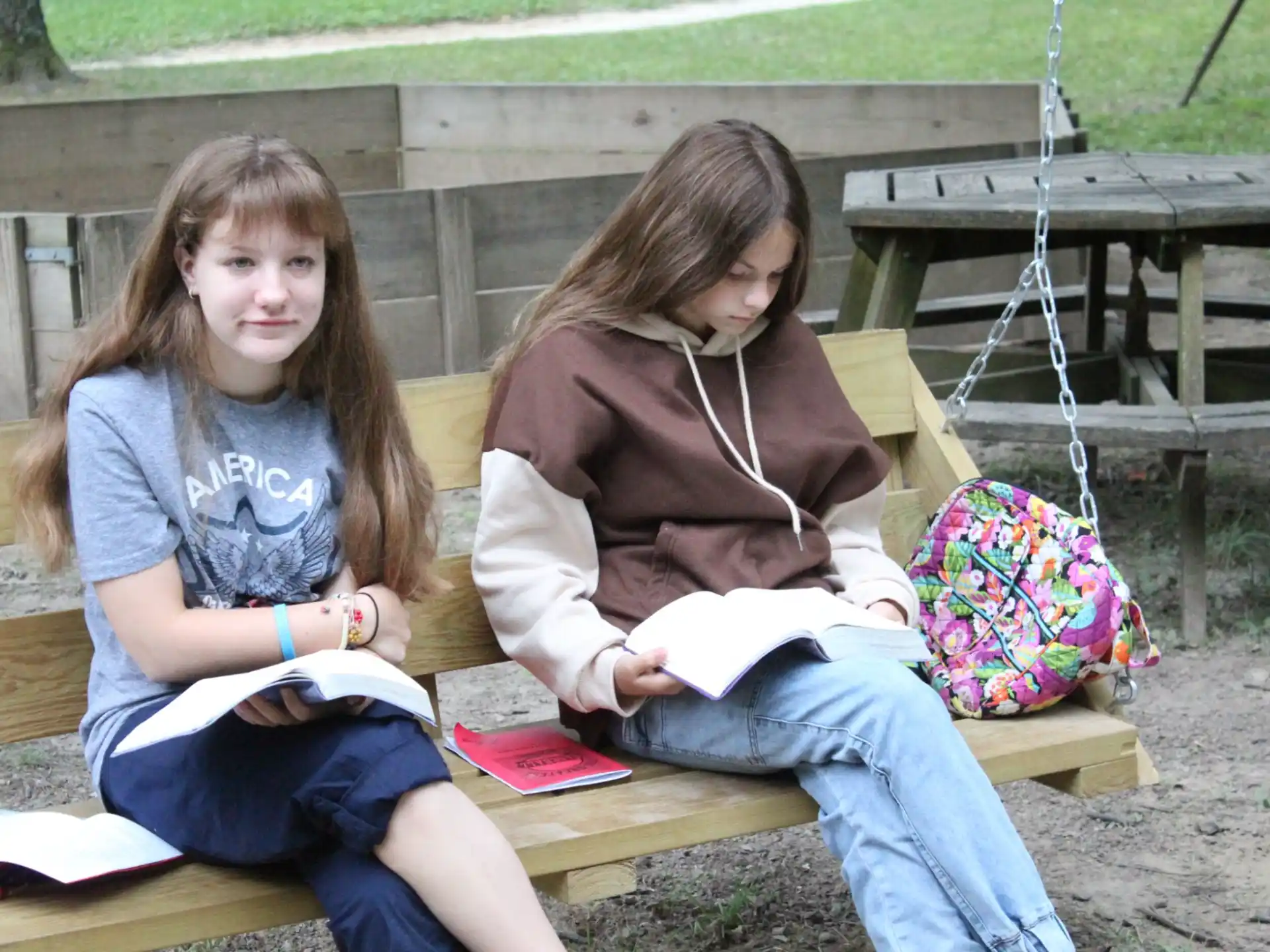 a couple of girls sitting on a bench