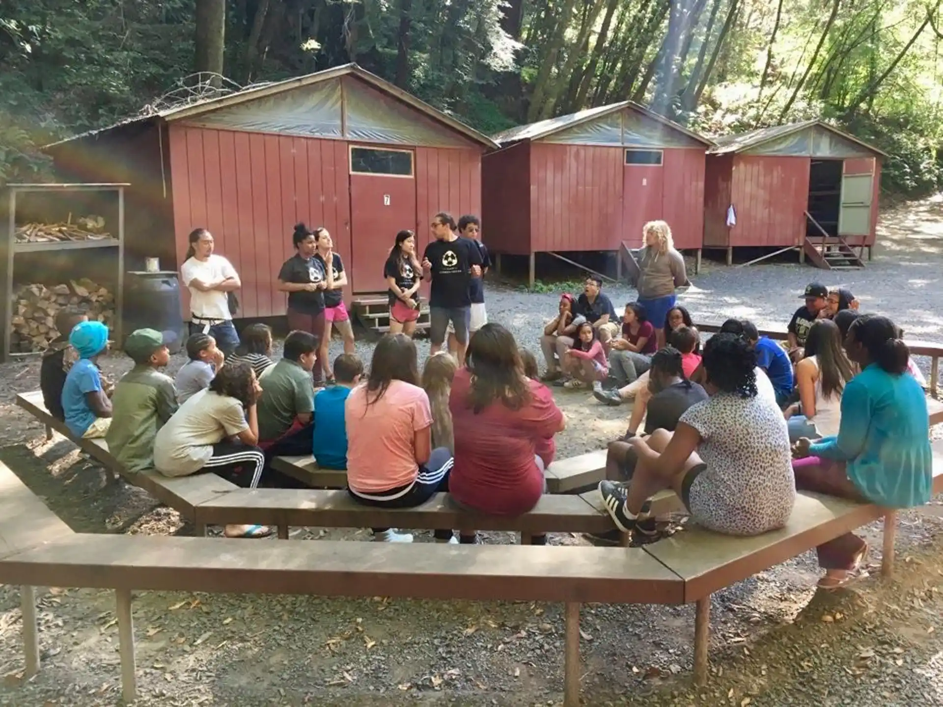 a group of people sitting on wooden benches in front of a building