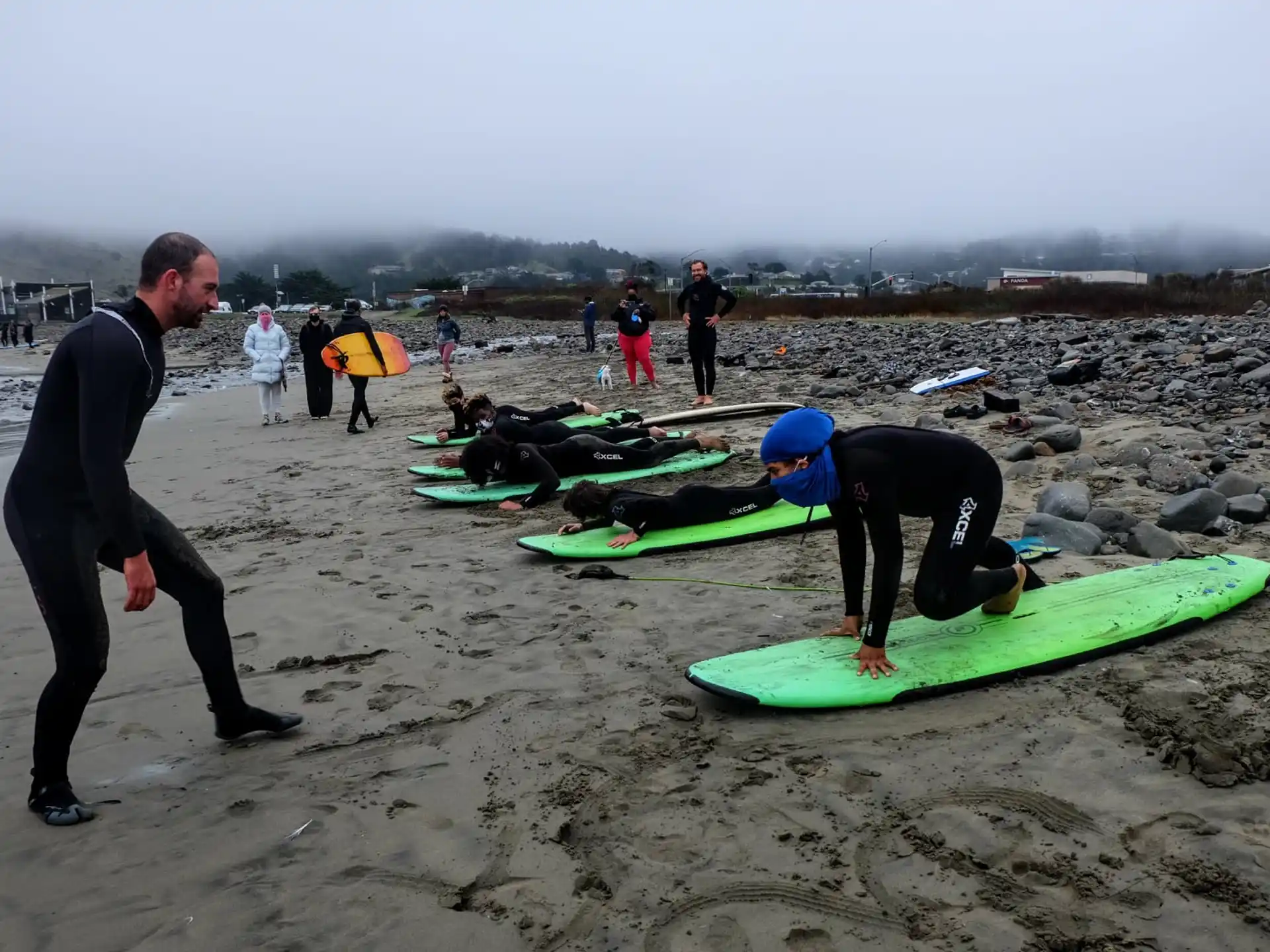 a group of surfers stand on the beach