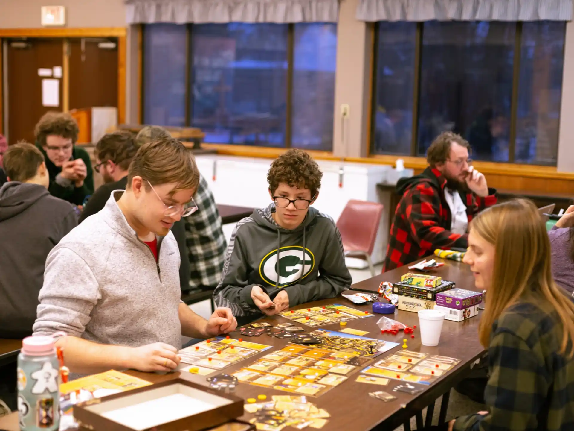 a group of people sitting at a table playing a board game
