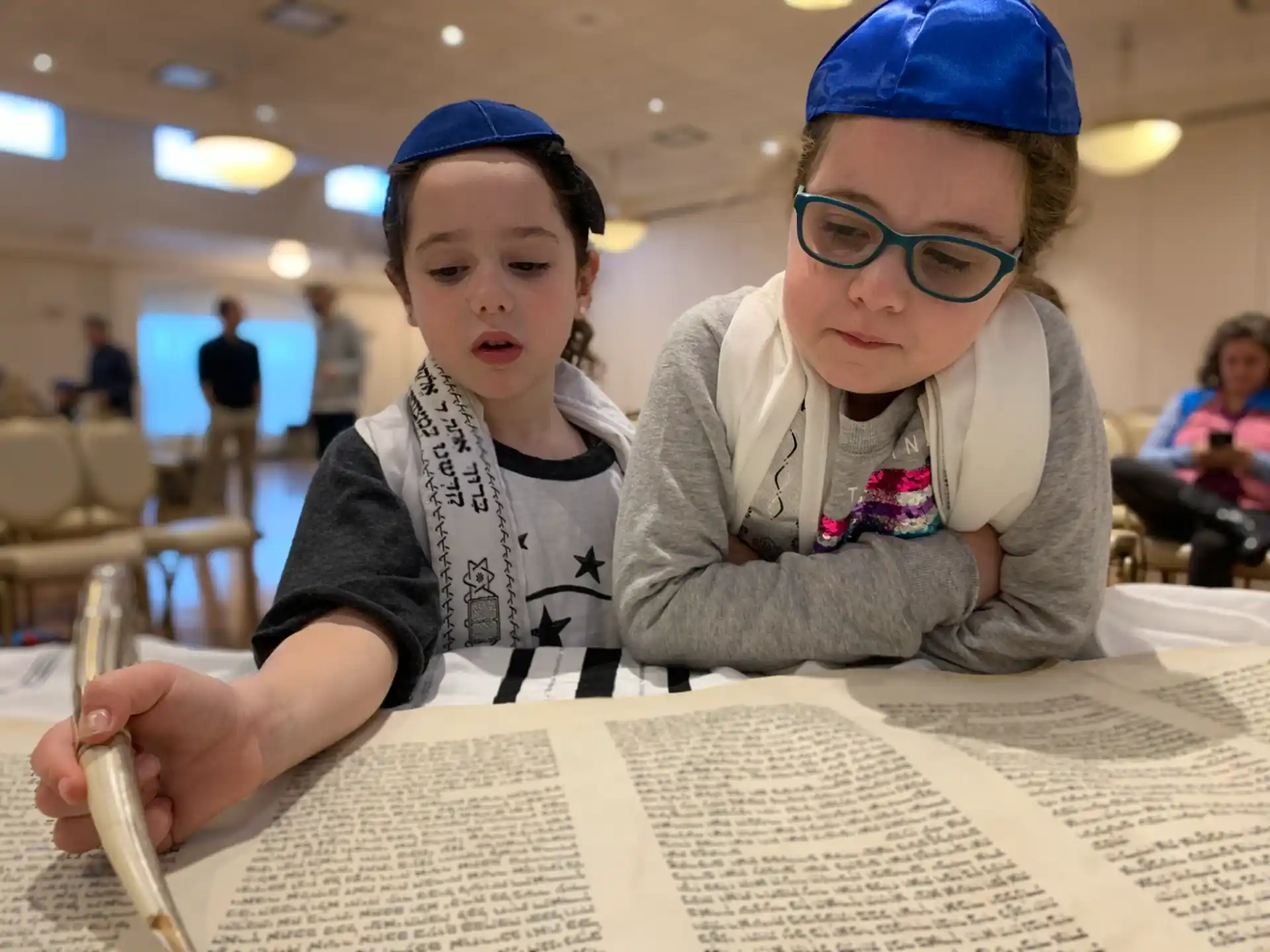 a couple of girls wearing blue glasses and sitting at a table