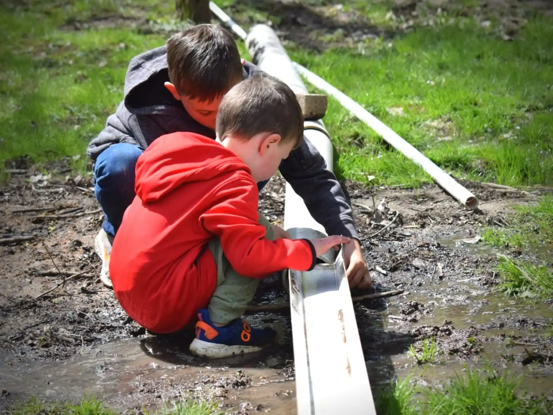 a group of boys playing with a white pipe
