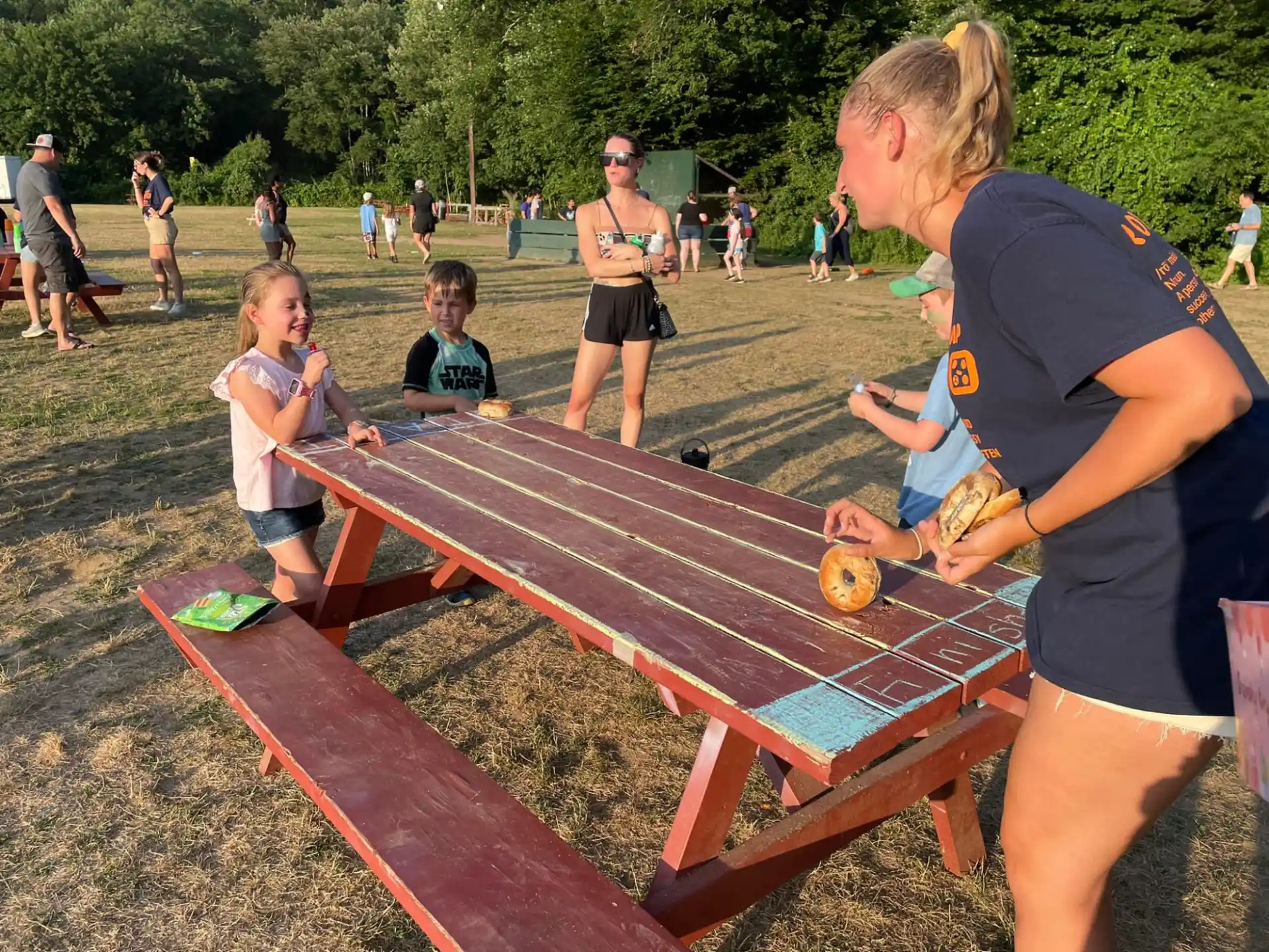 a person and a group of children playing on a wooden table