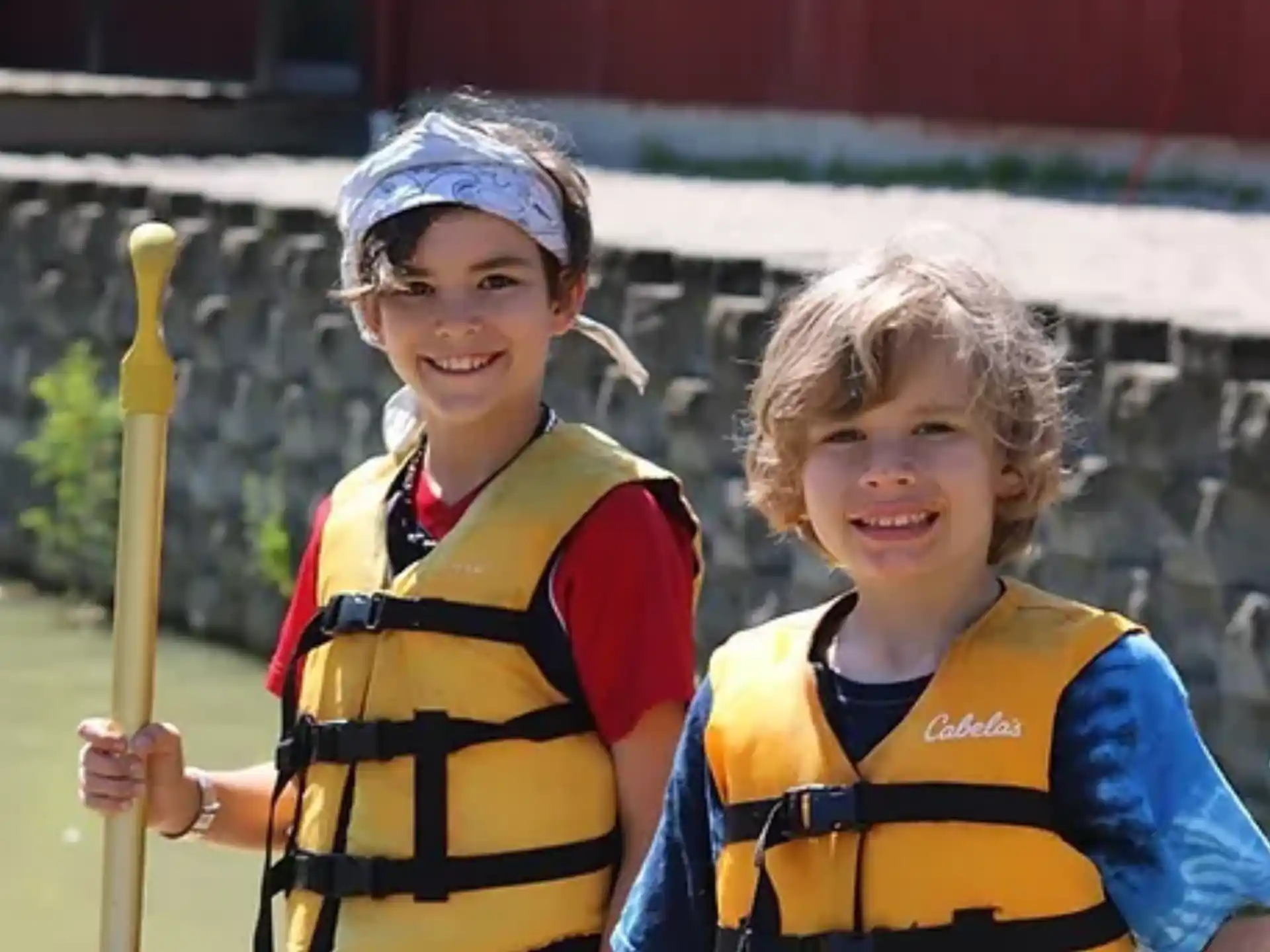 a couple of kids holding yellow bats