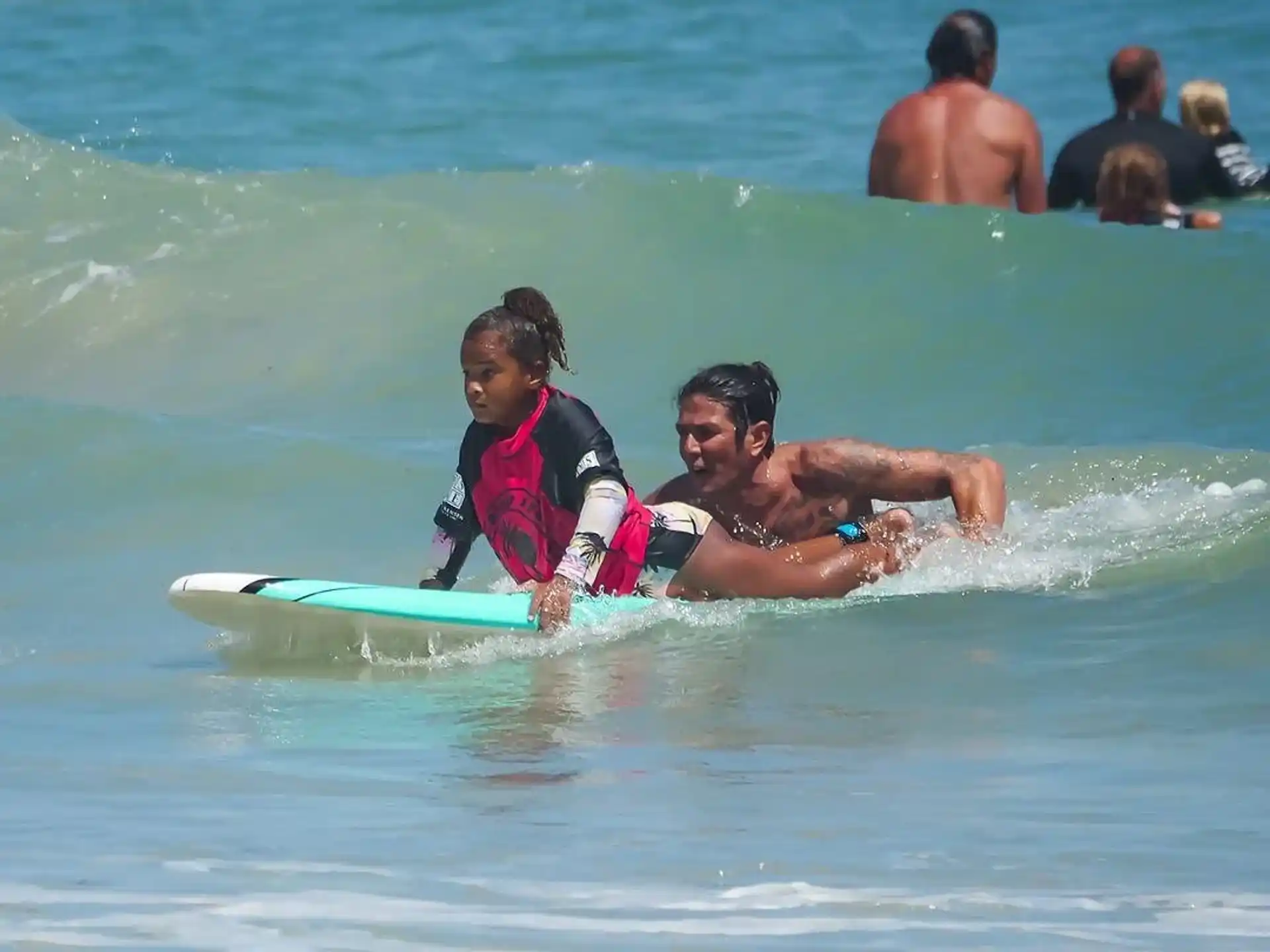 a couple of people surfing in the sea