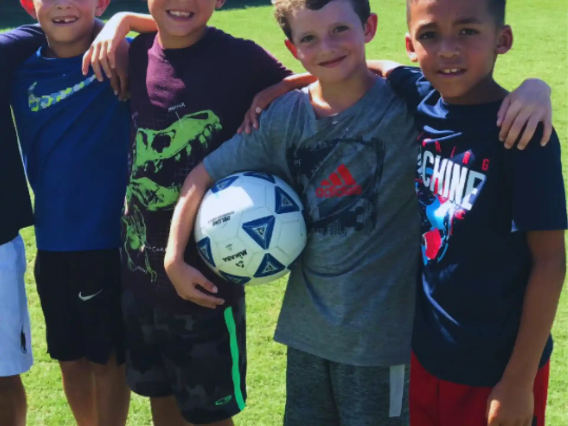a group of boys holding a football ball