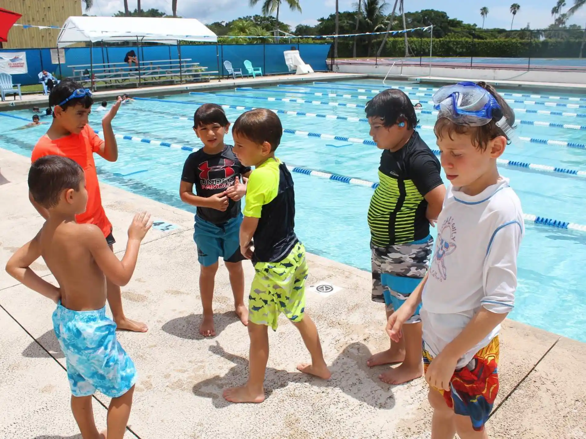 a group of kids standing by a pool