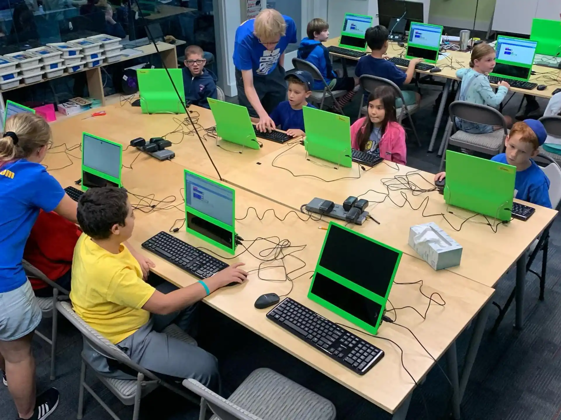 a group of people sitting at a table with computers