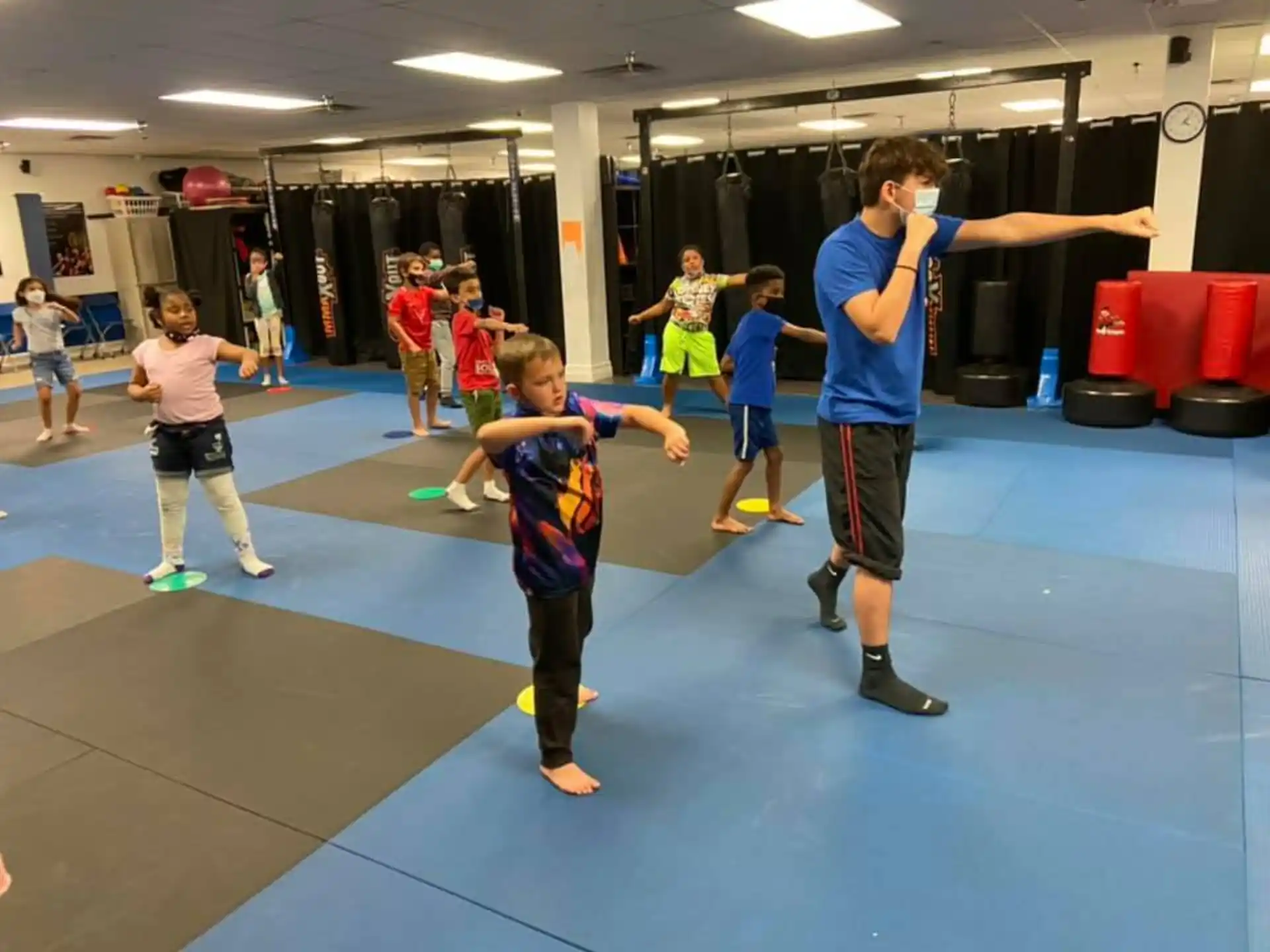 a group of children playing on a mat in a gym