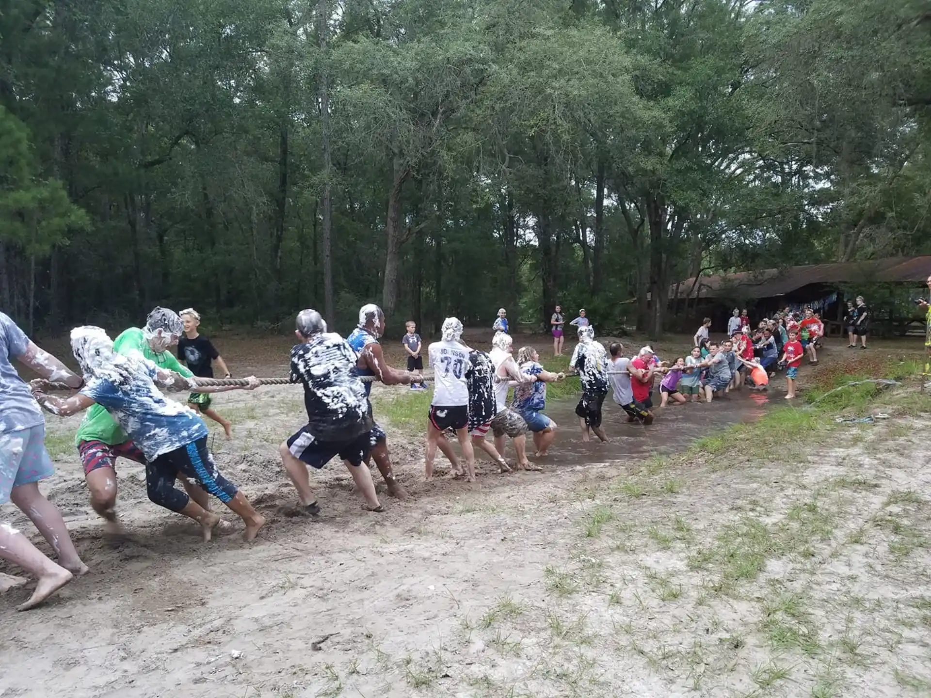 a group of people running in a mud field