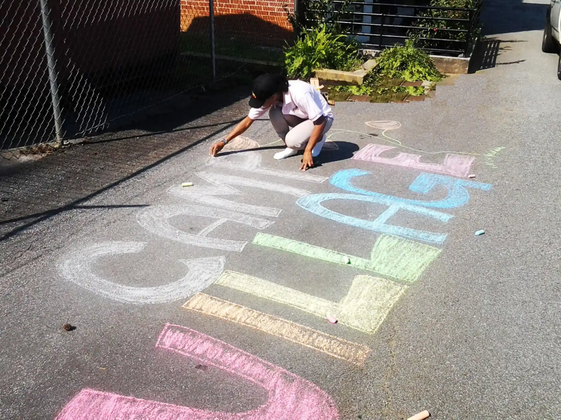 a person kneeling on a sidewalk