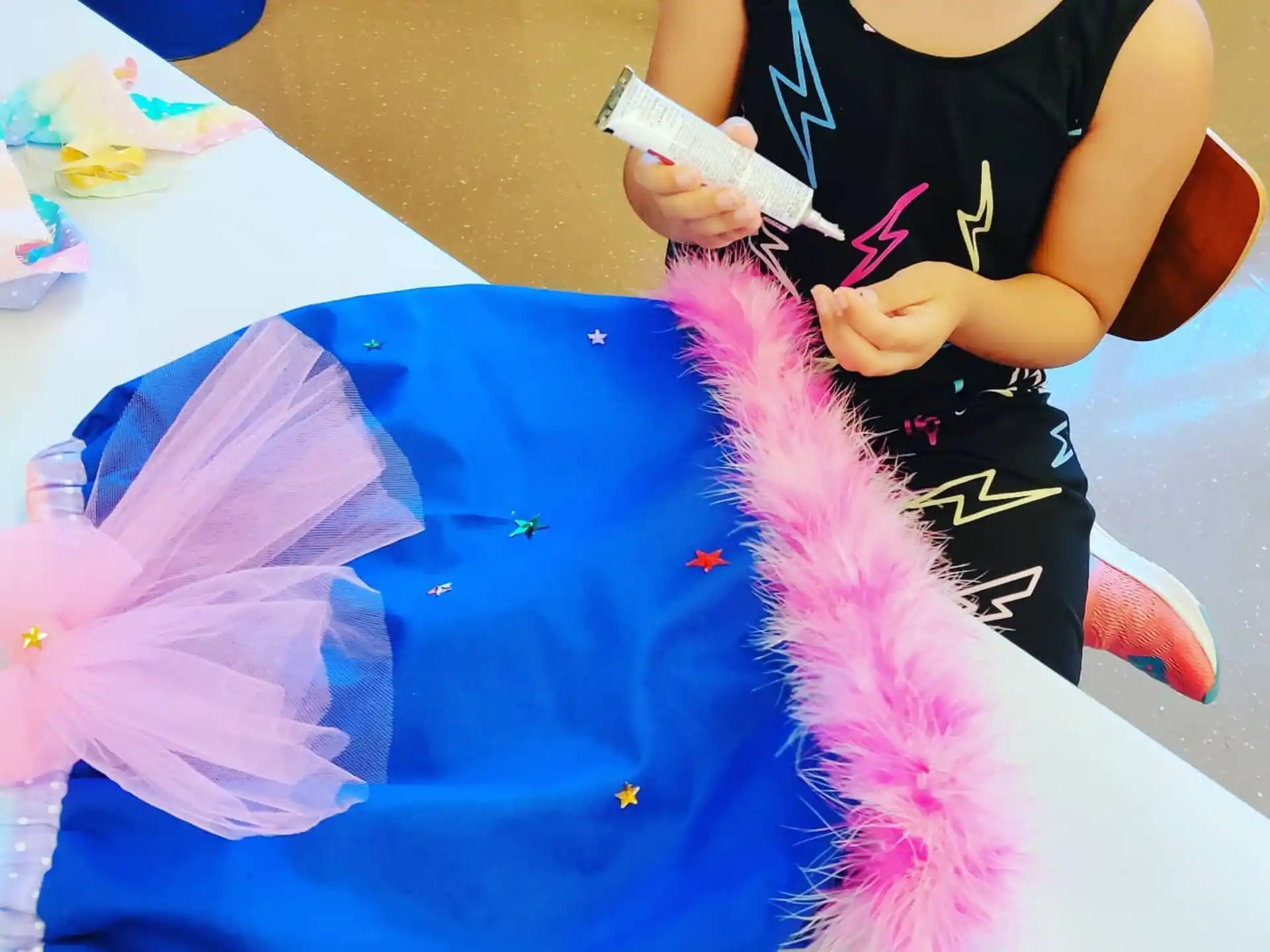 a woman painting a blue piece of paper