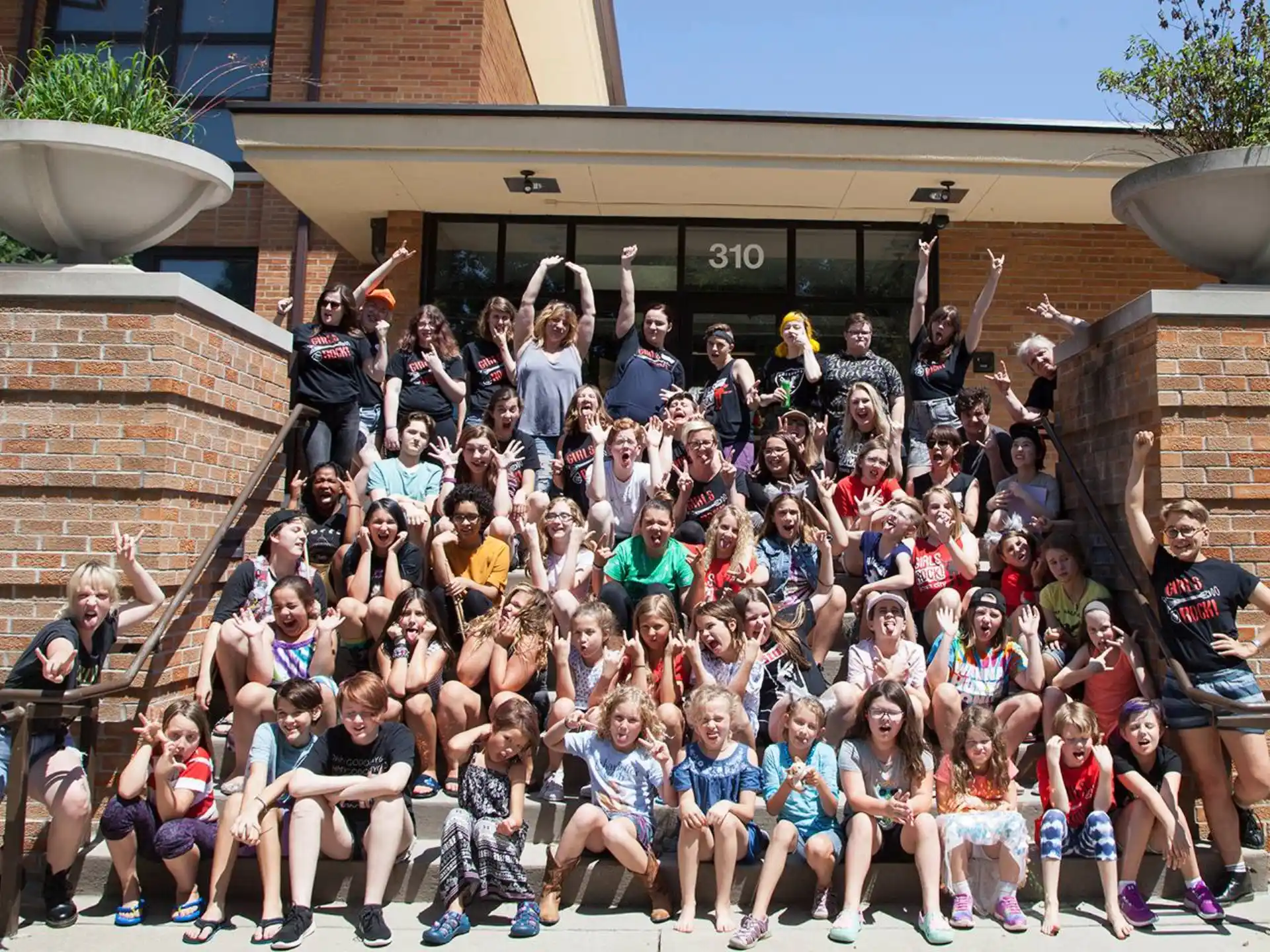 a group of people posing for a photo on some stairs