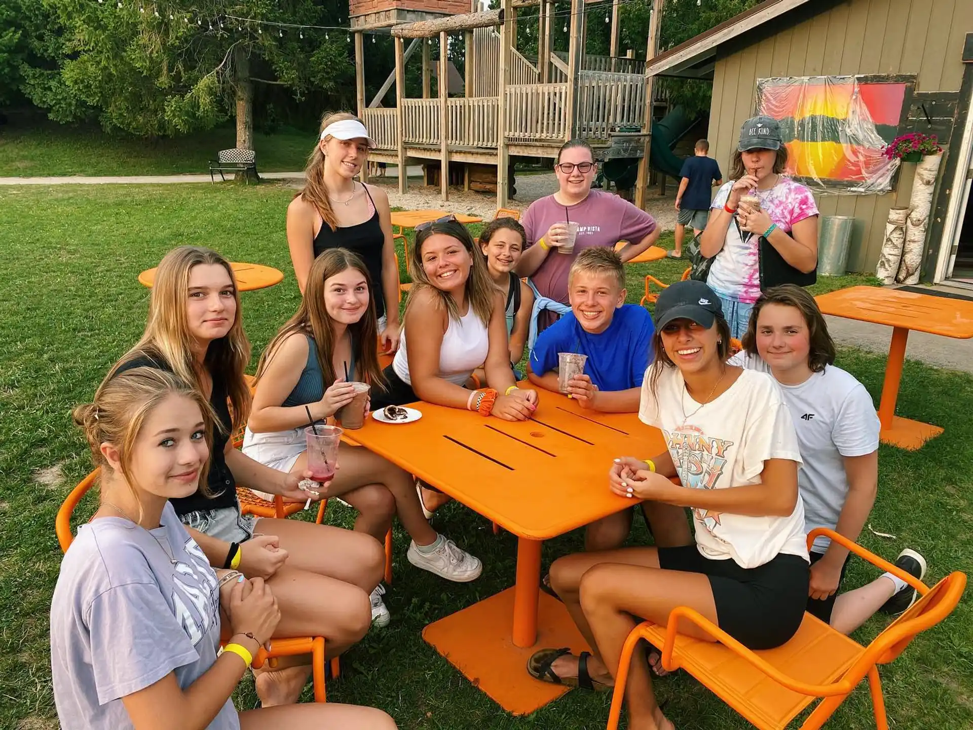 a group of people sitting around a table outside