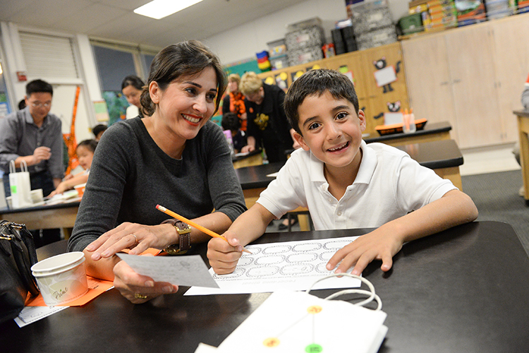 a couple of people sitting at a table with a pencil and paper