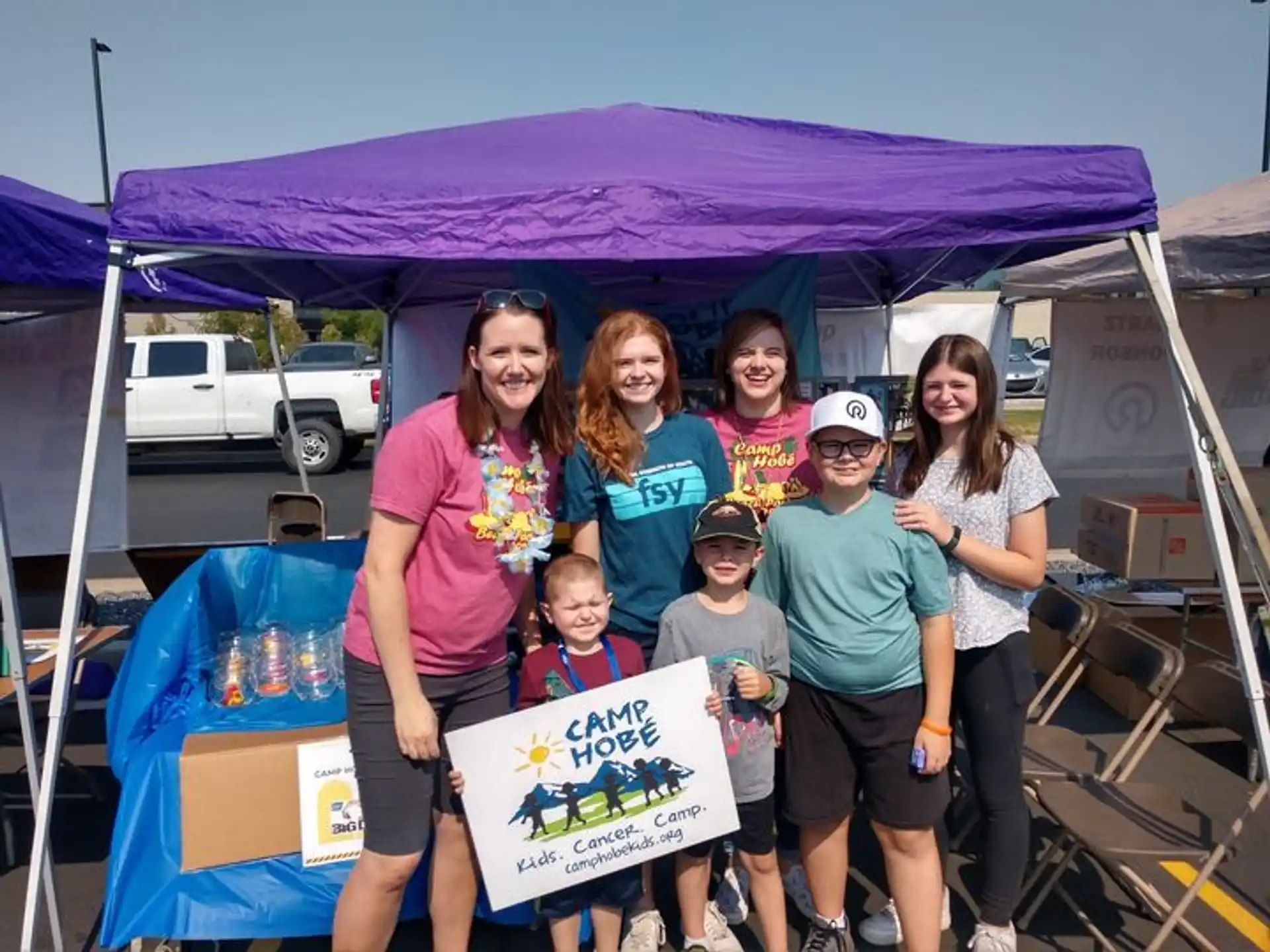 a group of people posing for a photo under a tent