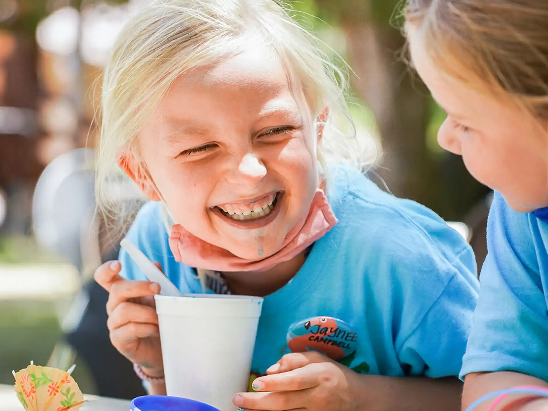 a young girl smiling and holding a cup of coffee