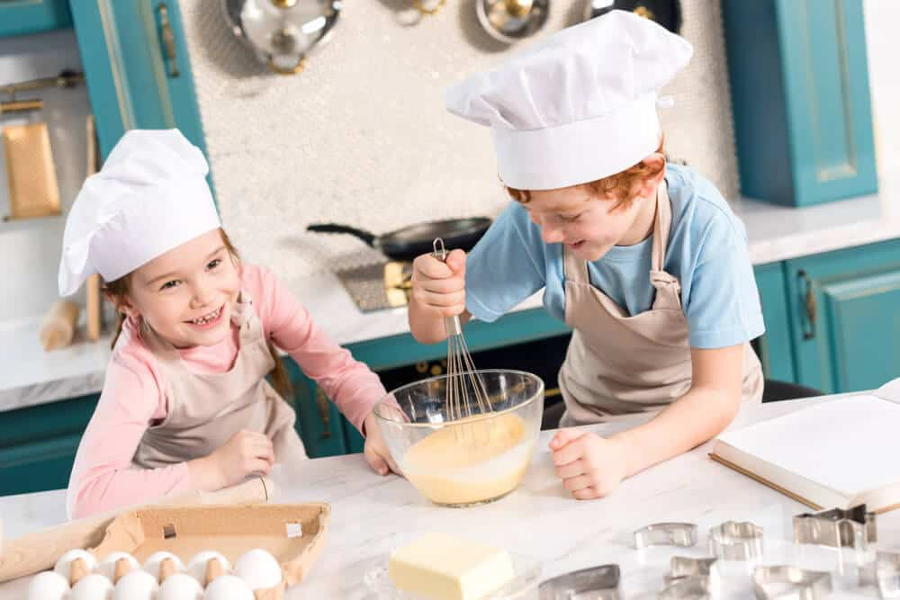 a couple of kids wearing chef hats